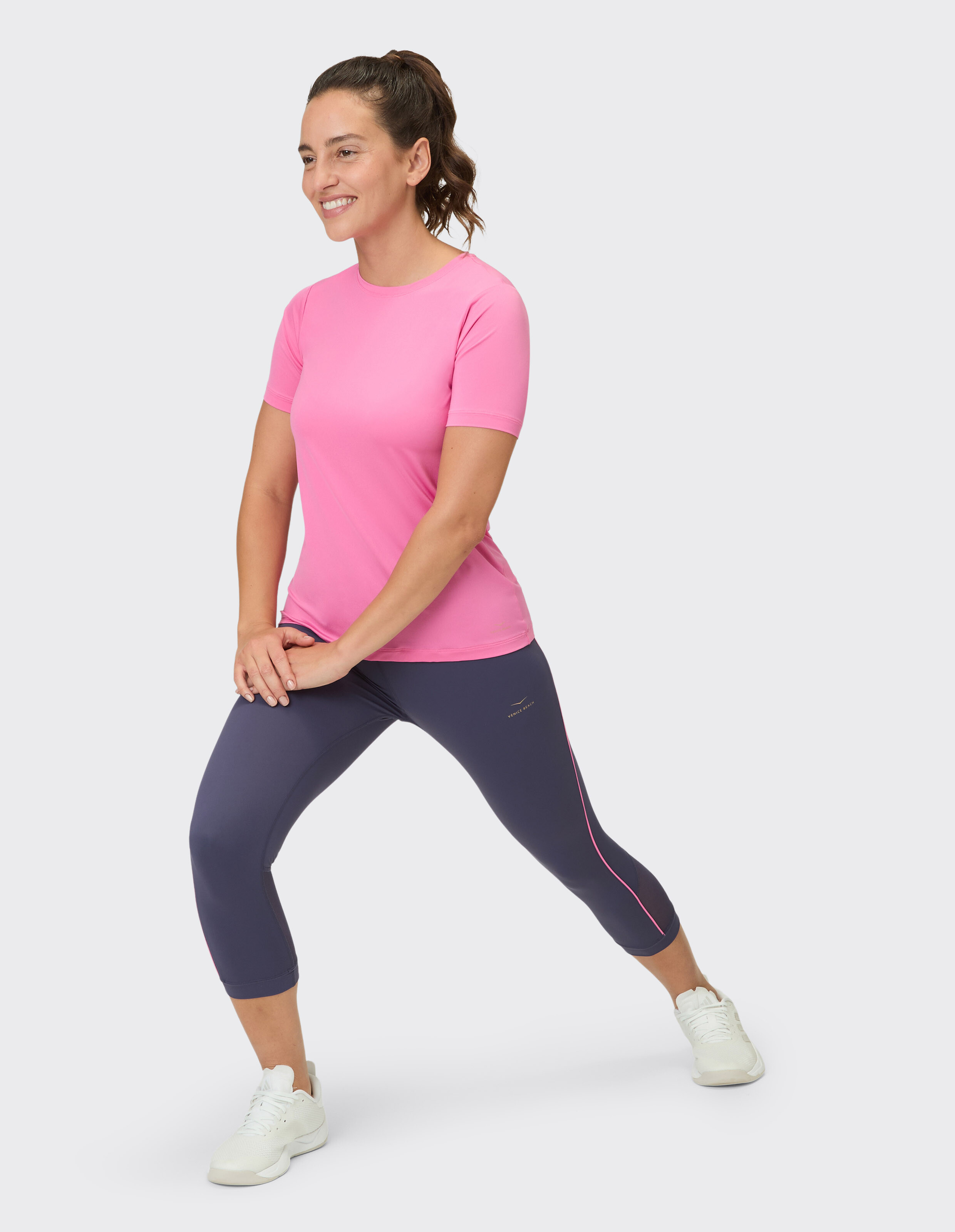 Frau trägt die 3/4-Tights Kimberly von Venice Beach und ein rosa T-Shirt für aktive Freizeitkleidung.