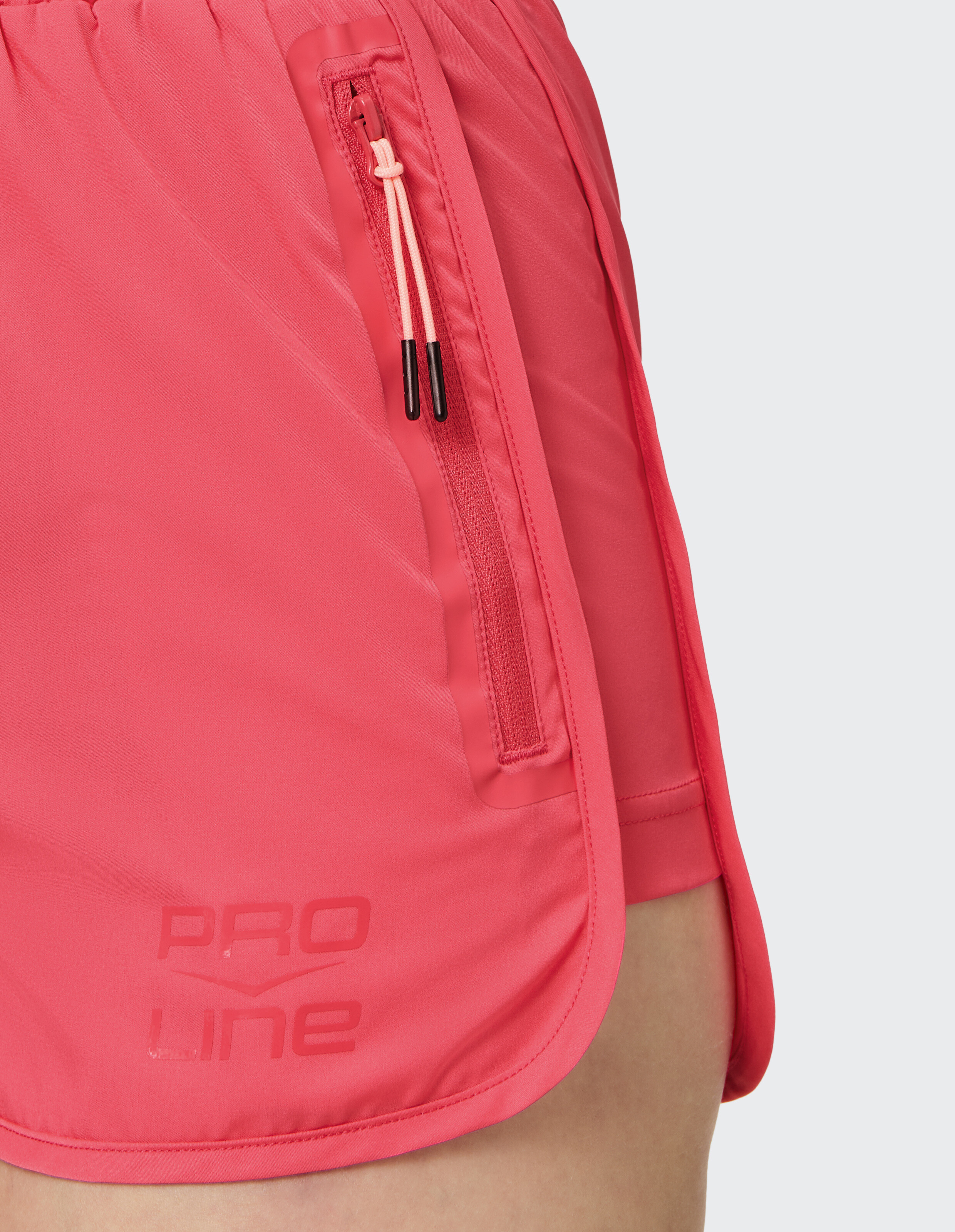 Nahaufnahme einer rosa Sportshorts mit Reißverschlusstasche und PRO LINE-Branding.