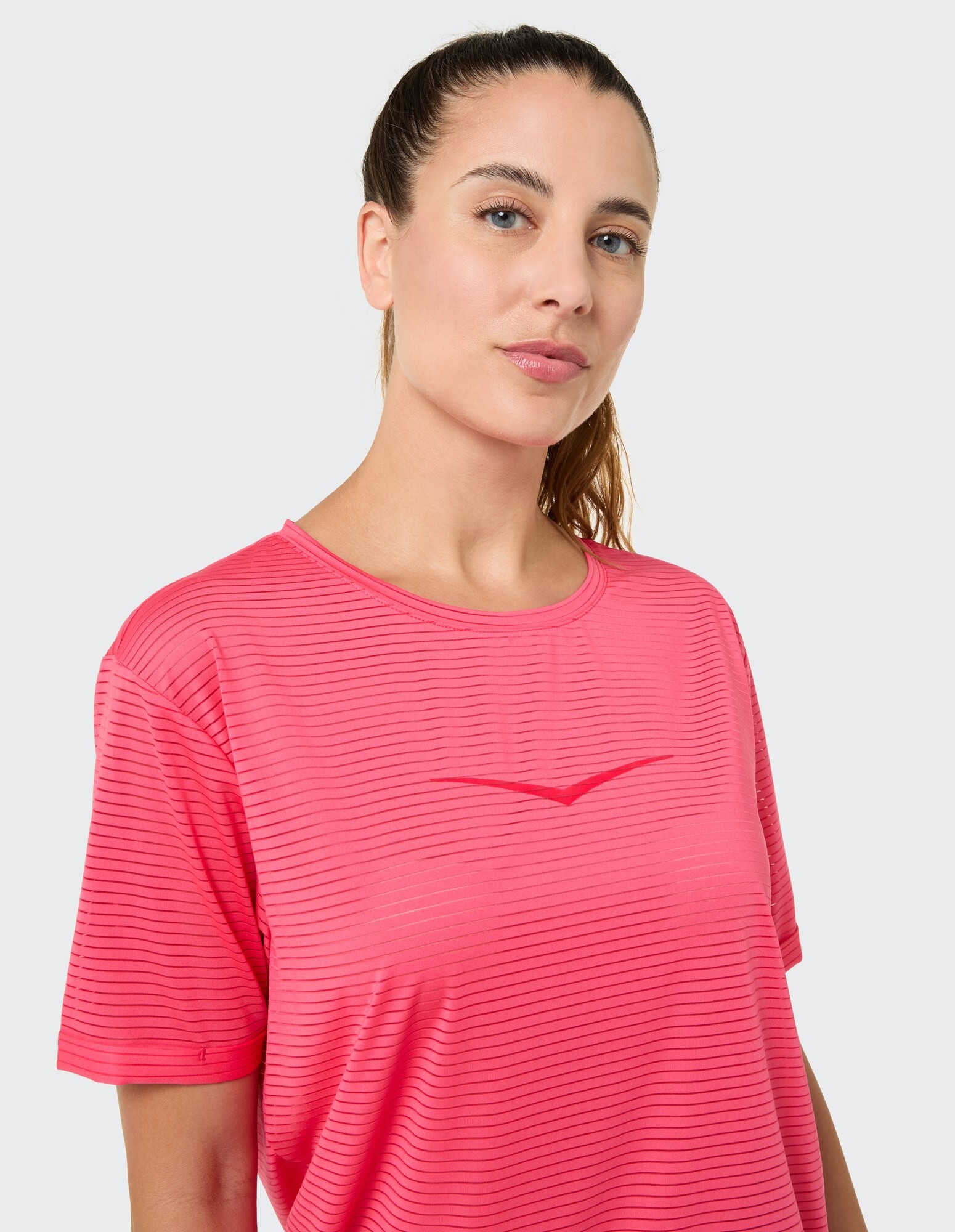 Frau in einem rosa gestreiften Freizeit-T-Shirt, perfekt für sportliche Kleidung oder zum Faulenzen.