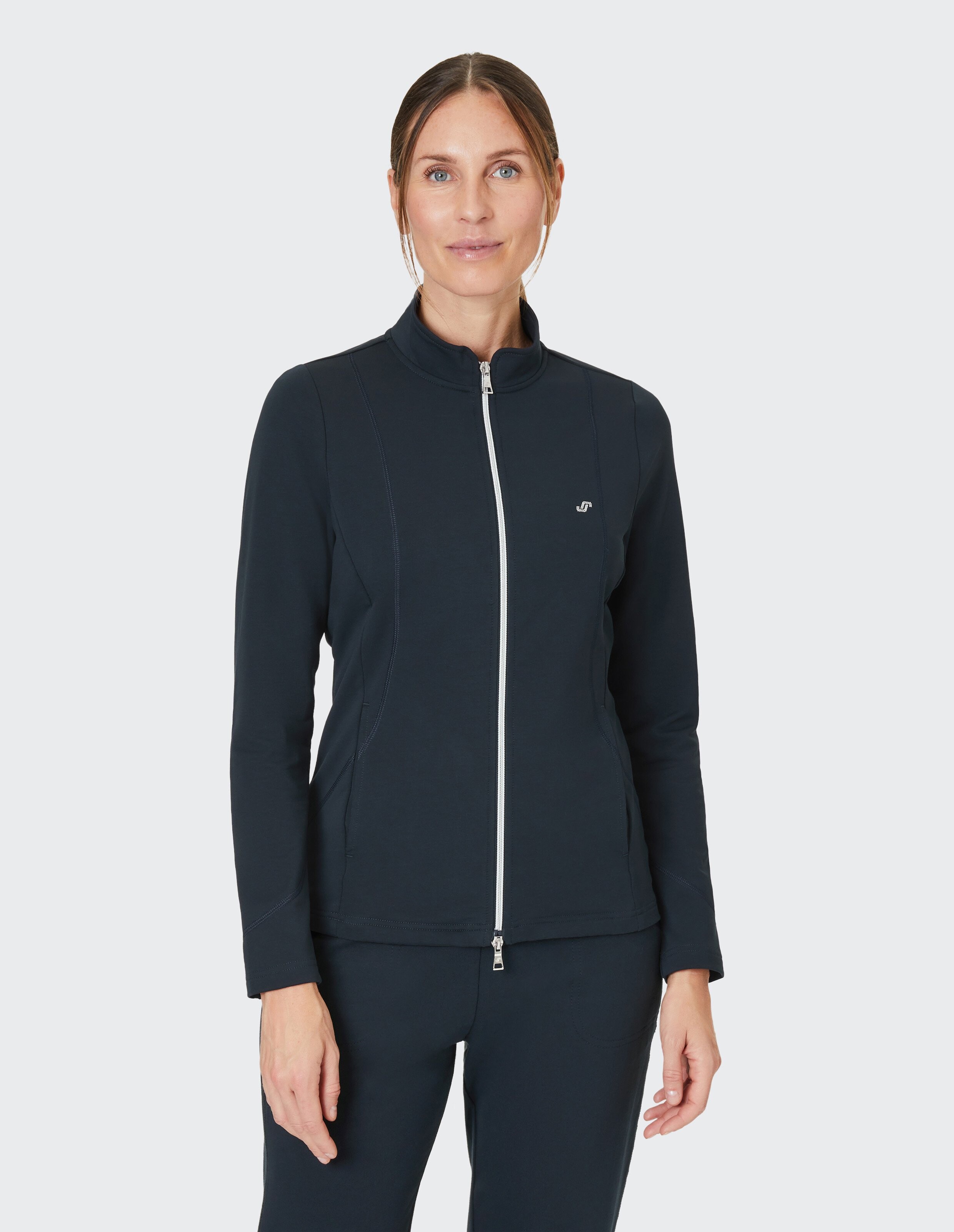 Dunkelblaue Damenjacke mit weißem Reißverschluss, Stehkragen und dezentem Logo links auf der Brust.