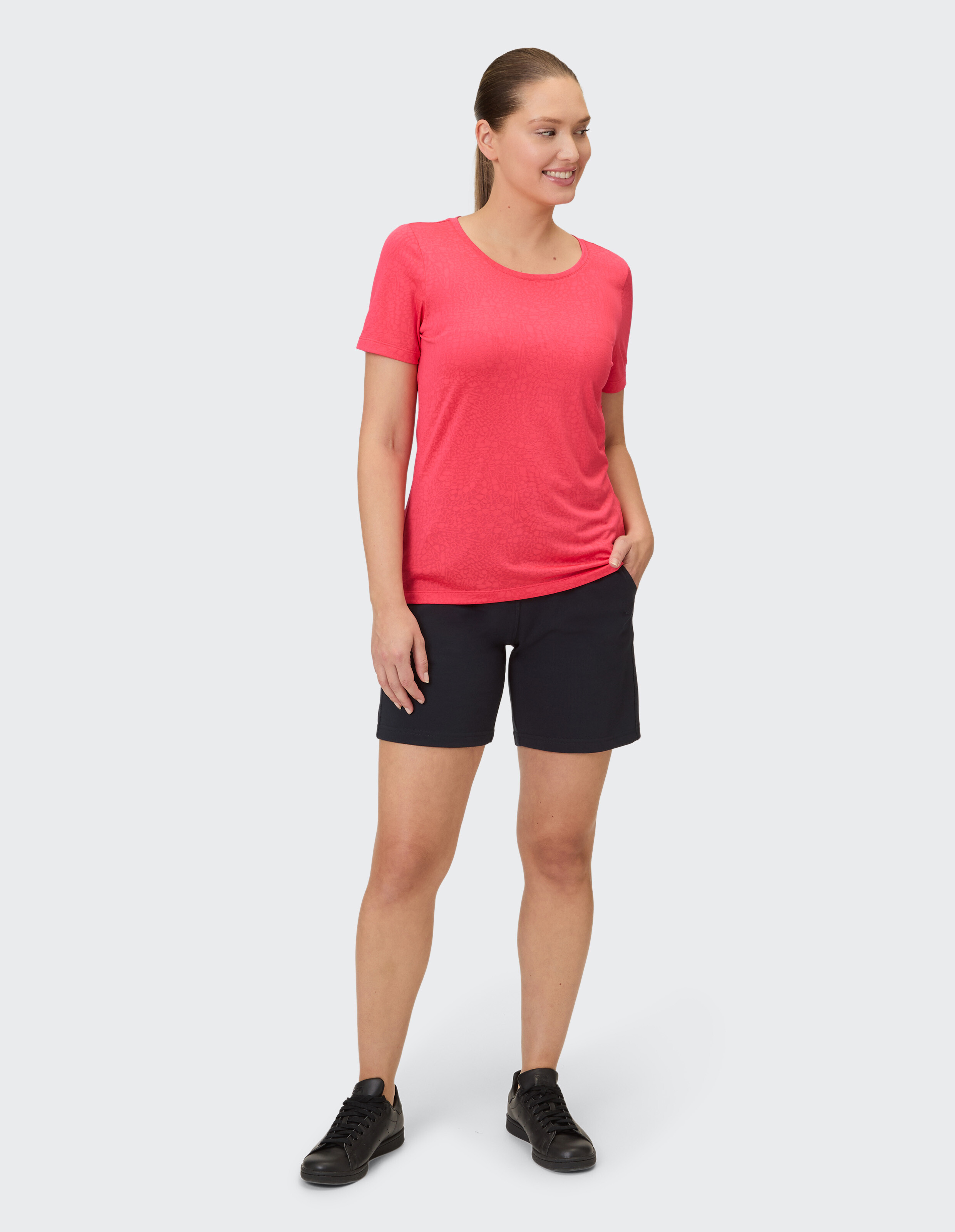 Frau in rosa T-Shirt und schwarzen Shorts, perfekt für Freizeitausflüge.