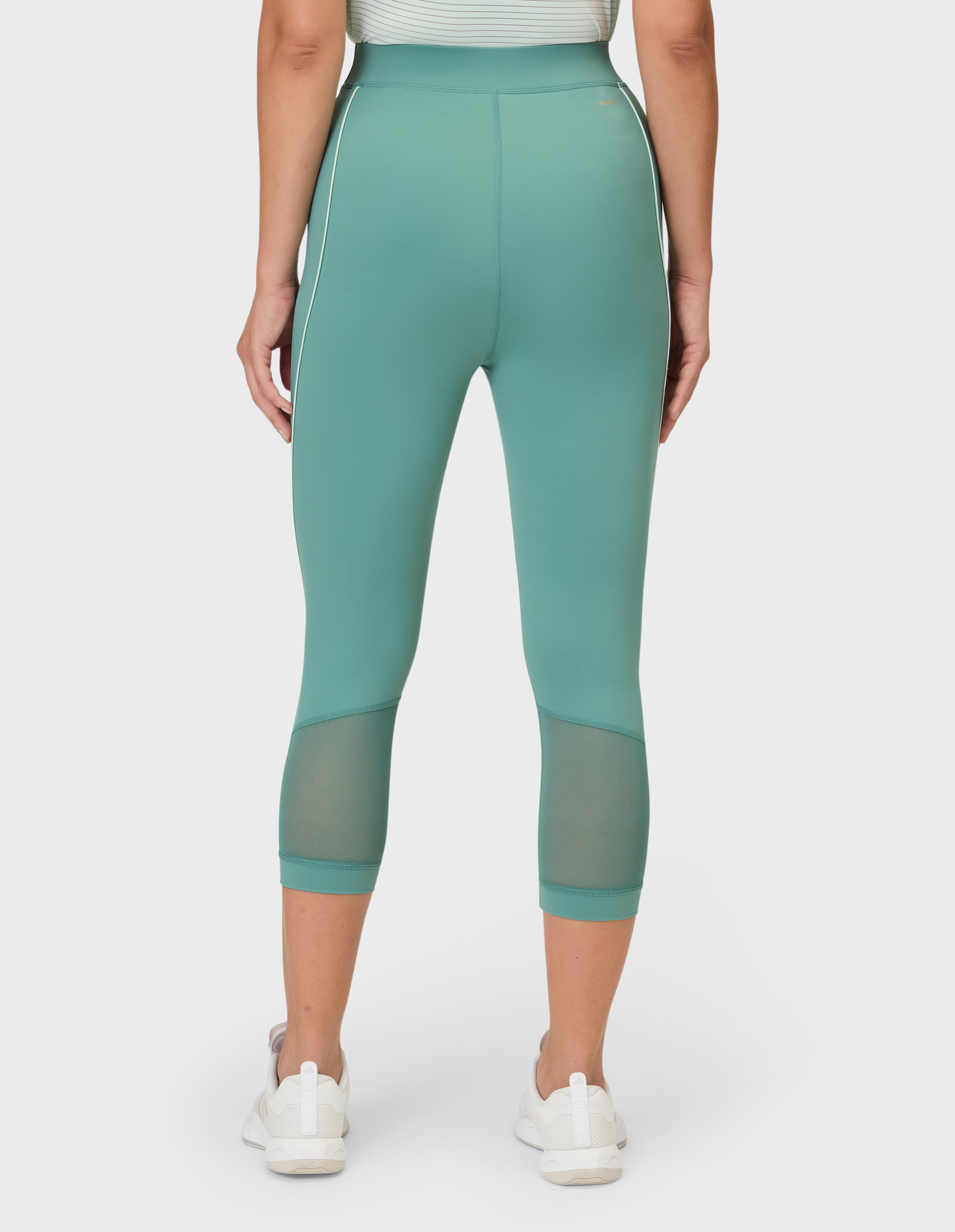 Rückansicht einer blaugrünen Capri-Leggings mit Mesh-Einsätzen, perfekt für Freizeitkleidung.