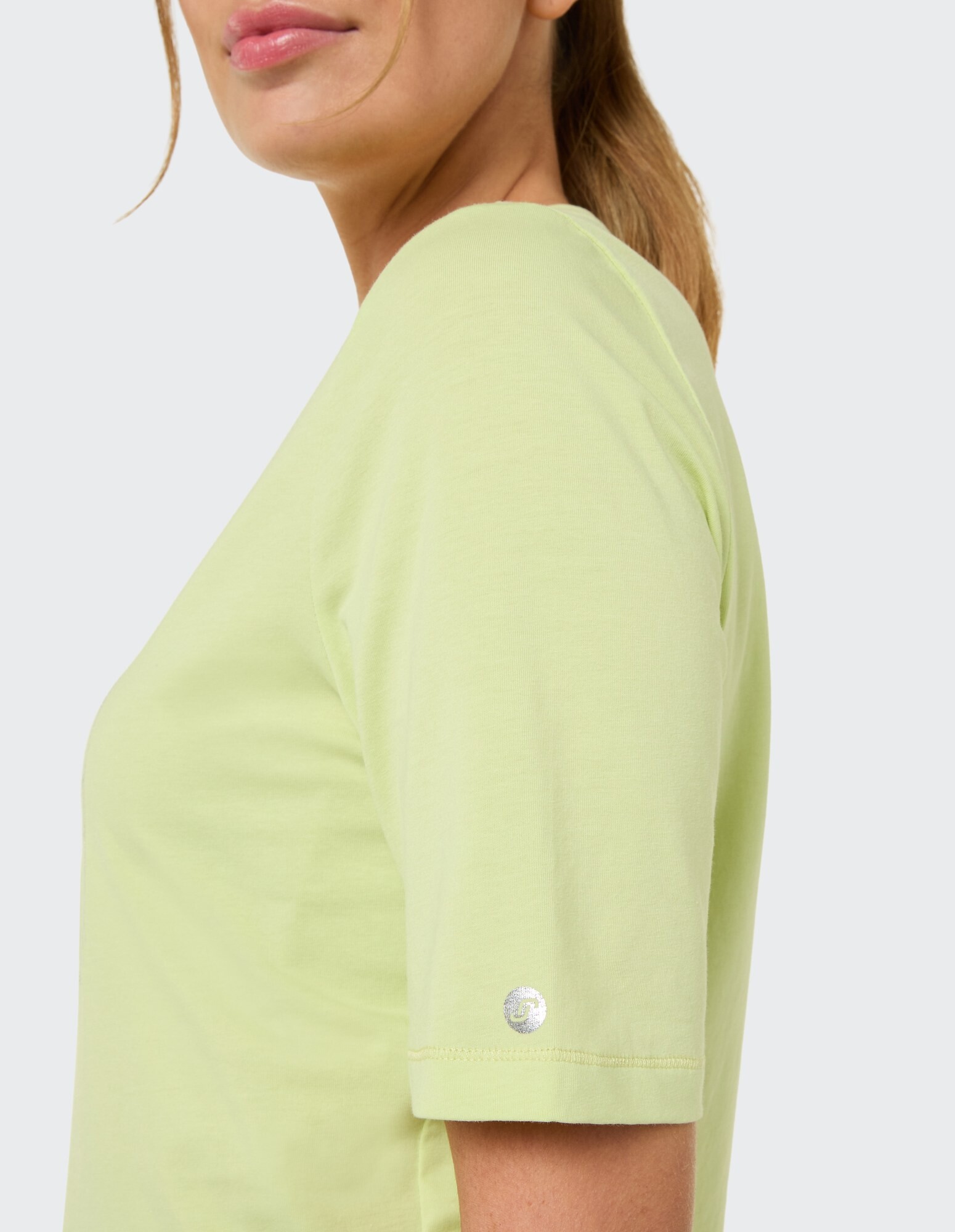 Hellgrünes Freizeit-T-Shirt mit kurzen Ärmeln und Logo-Detail am Ärmel.