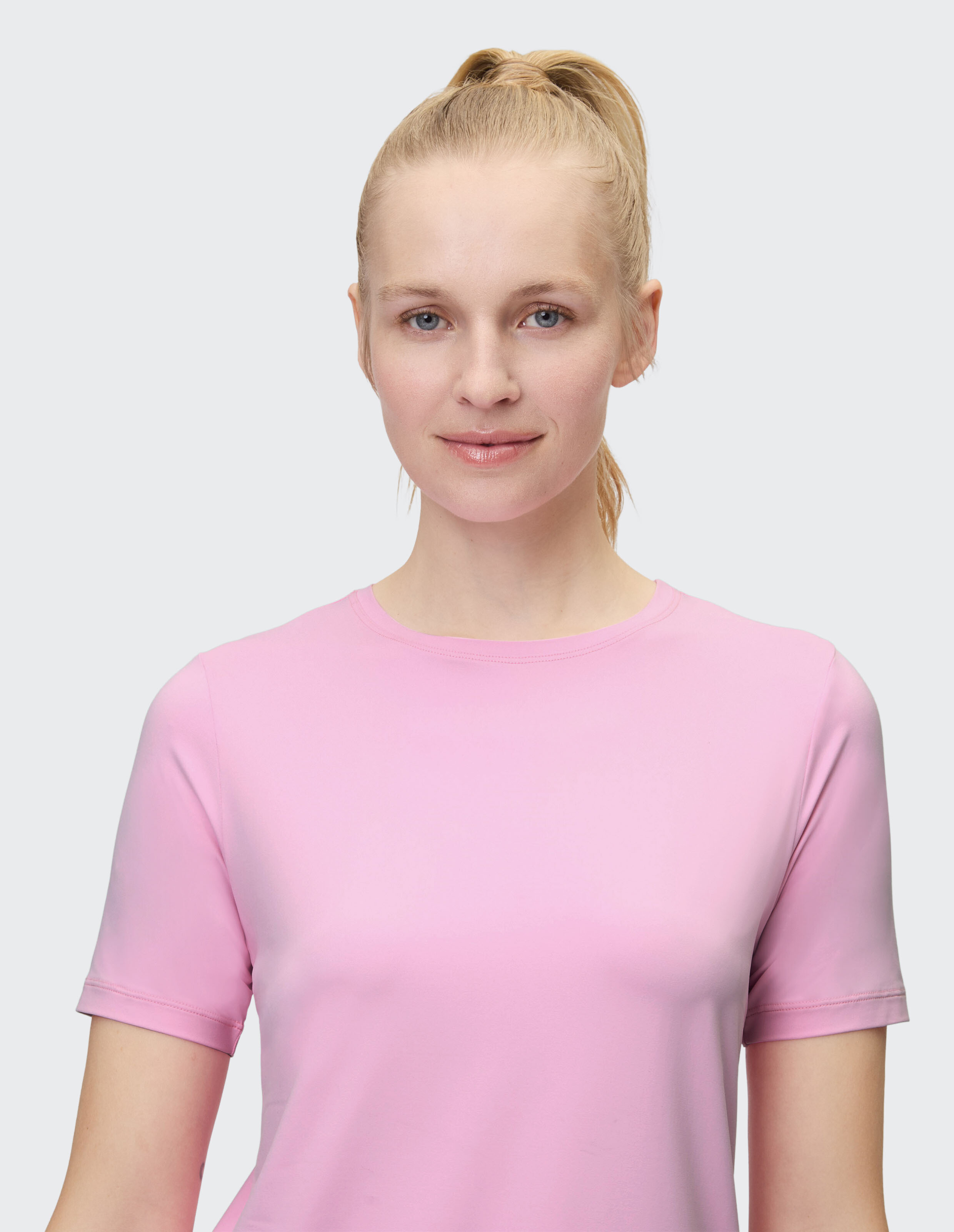 Frau trägt ein zartrosa Kurzarm-T-Shirt, perfekt für Freizeitausflüge.