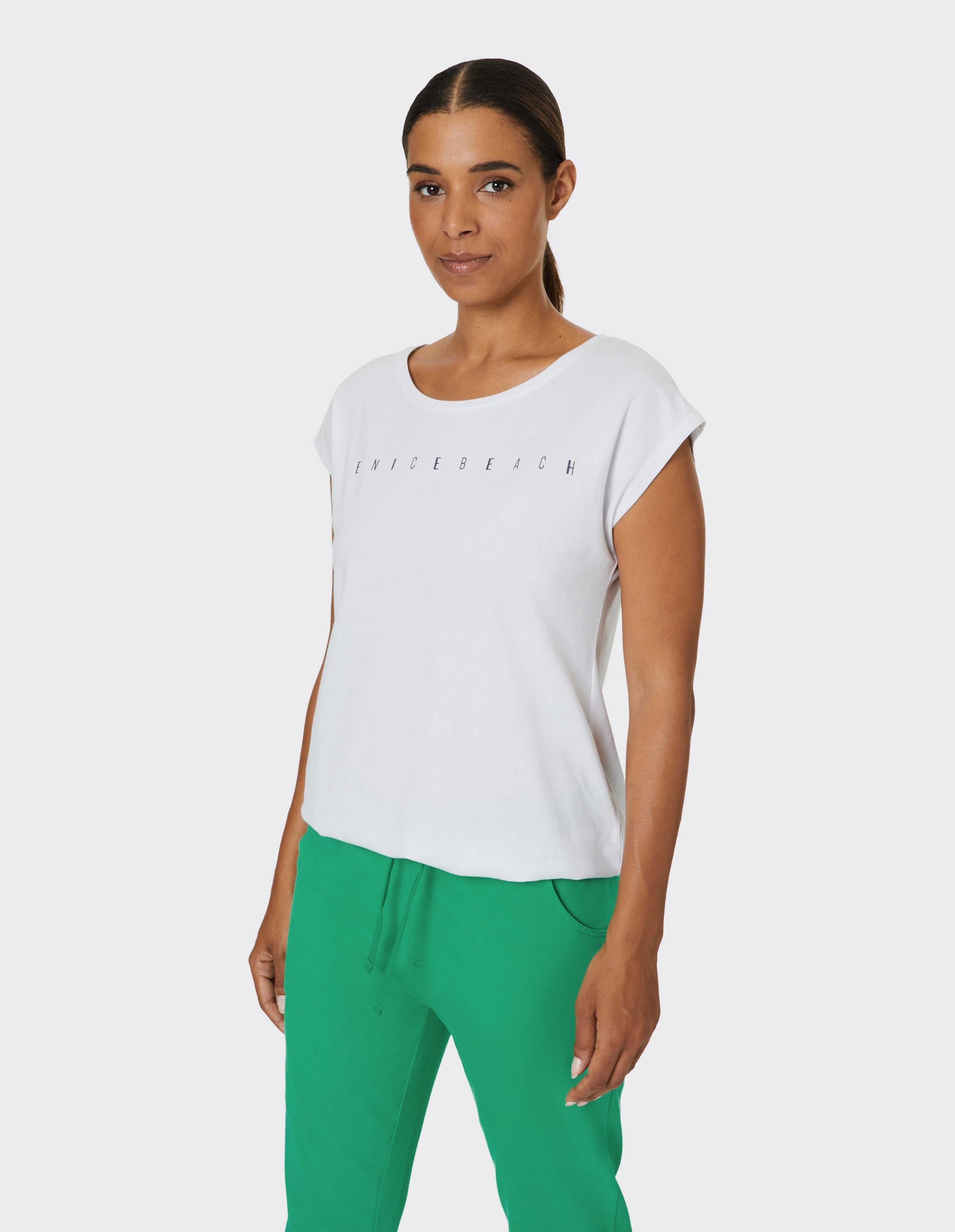 Frau trägt ein weißes Venice Beach Kurzarmshirt Wonder für lässigen Komfort.