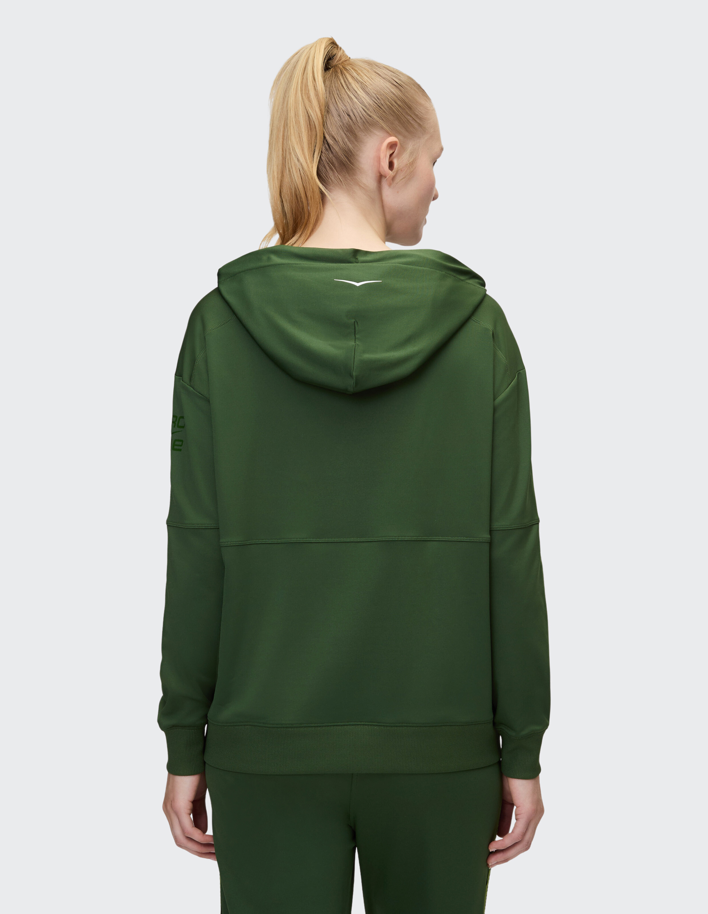 Rückansicht einer Frau in einem kuscheligen grünen Kapuzenpullover, perfekt für Freizeitkleidung.
