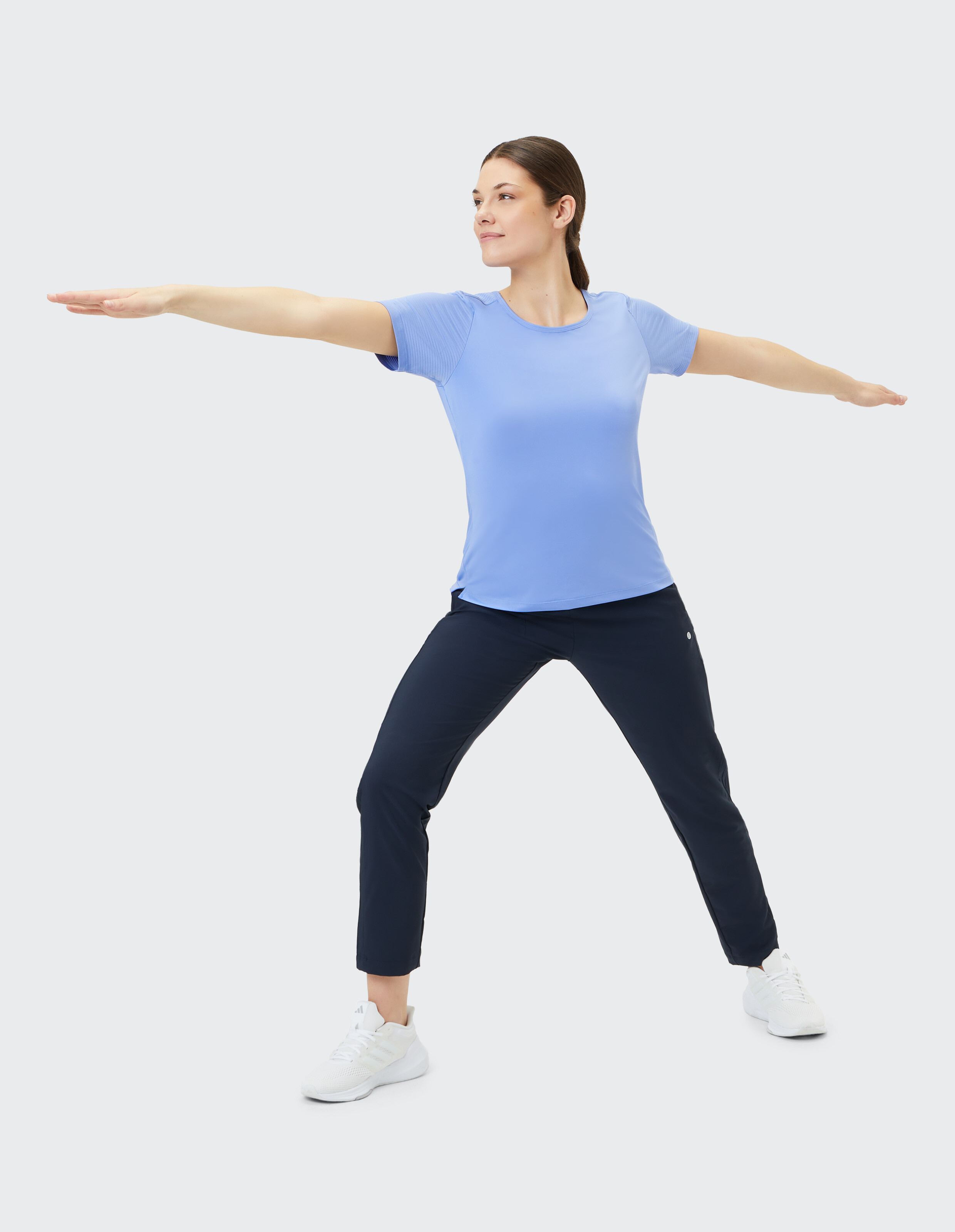 Frau in blauem T-Shirt und dunkler Hose beim Yoga, perfekt für bequeme Freizeitkleidung.