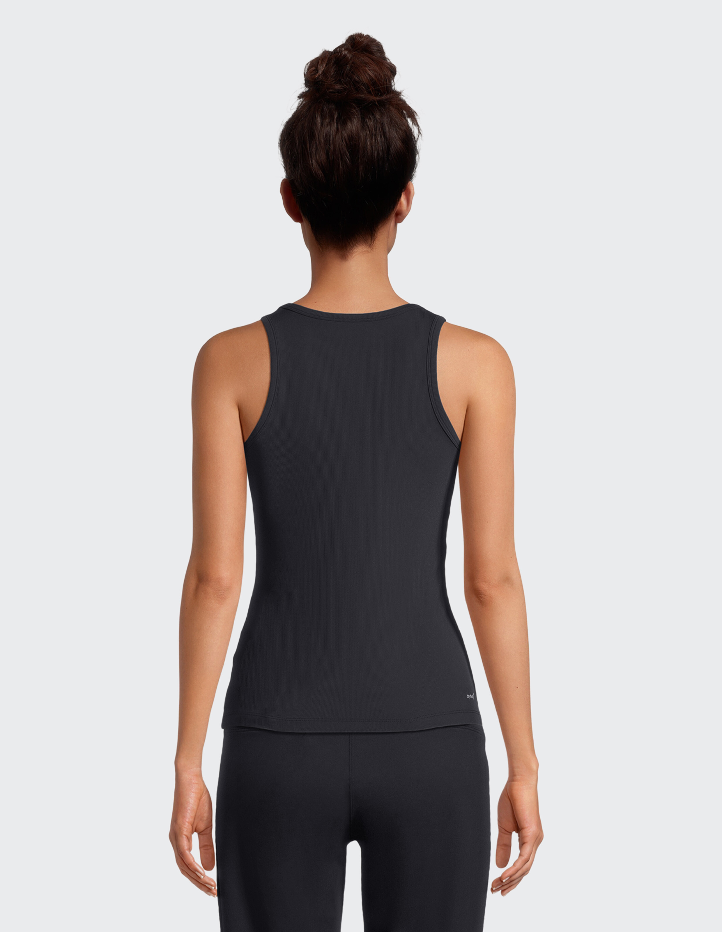 Rückansicht einer Frau, die ein schwarzes, geripptes Tanktop für lässige Lounge-Kleidung trägt.