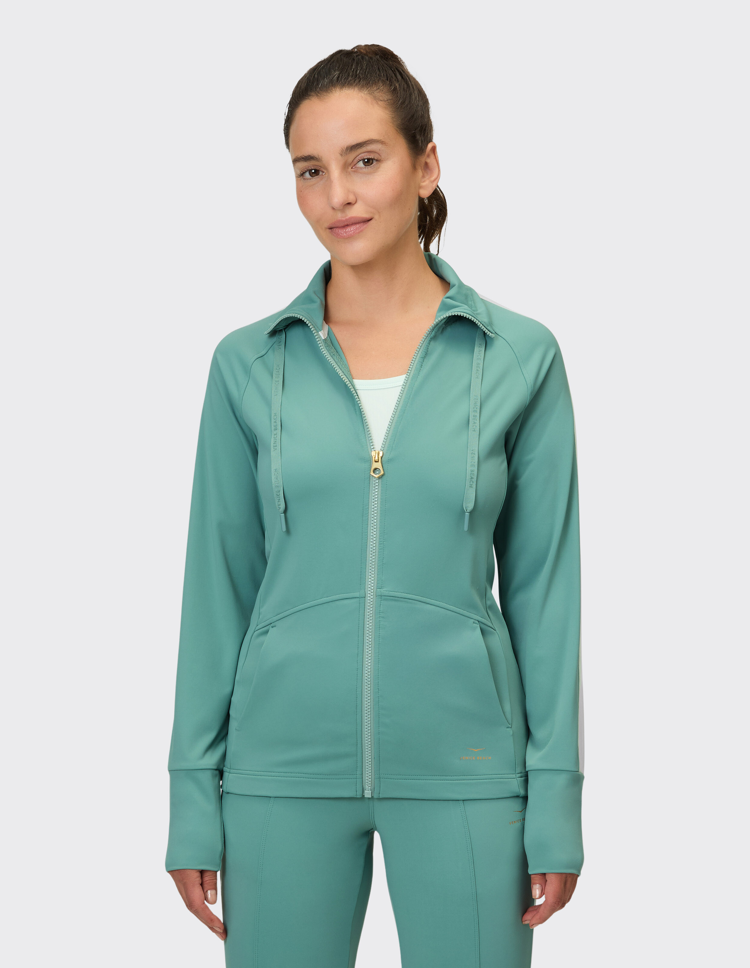 Frau trägt eine blaugrüne, funktionelle Jacke mit Reißverschluss von Venice Beach Morris für Freizeitkleidung.