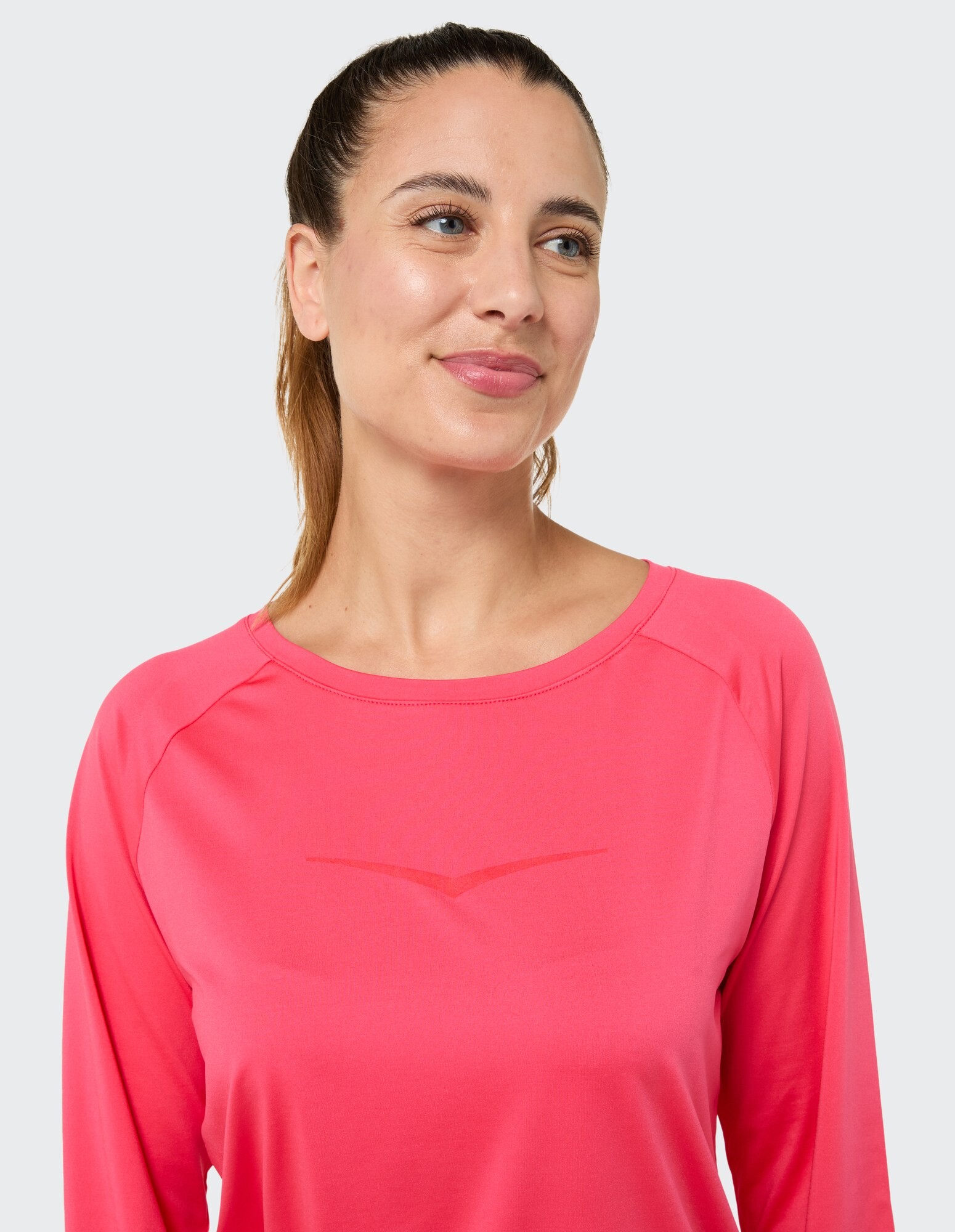 Lächelnde Frau in einem rosa Langarmshirt, perfekt für Freizeitkleidung.