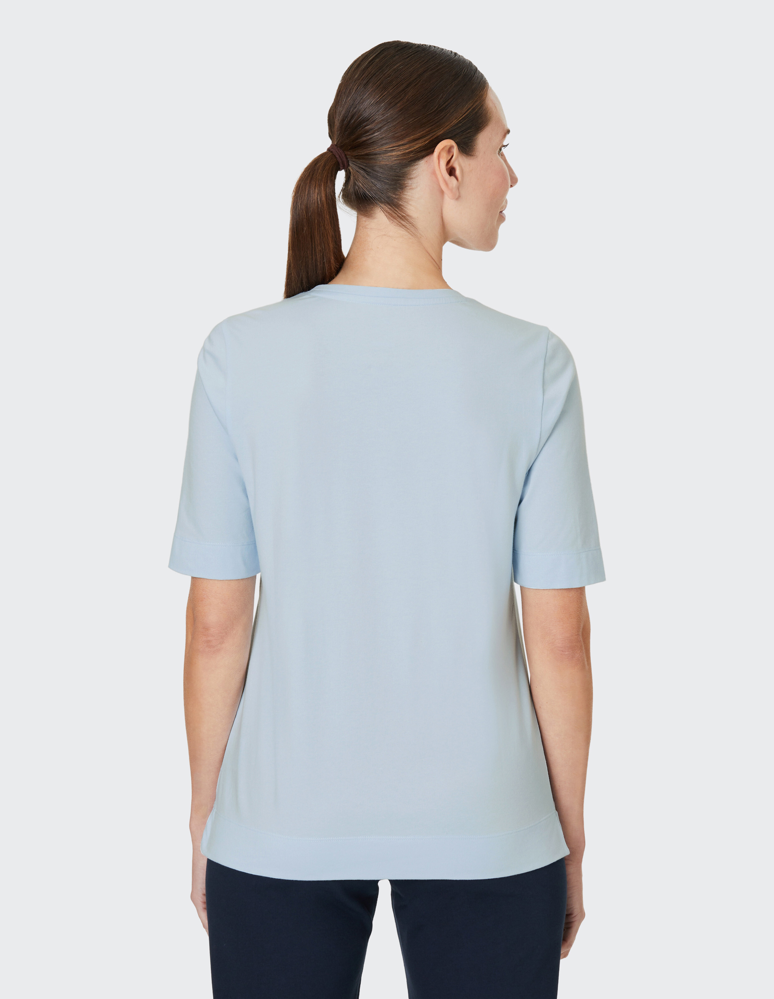 Hellblaues T-Shirt mit zweigeteiltem Kunstmotiv; links blaues Blumenbild, rechts rosa abstraction, darunter der Schriftzug \\\\\\\\\\\\\\\"Joy\\\\\\\\\\\\\\\""."