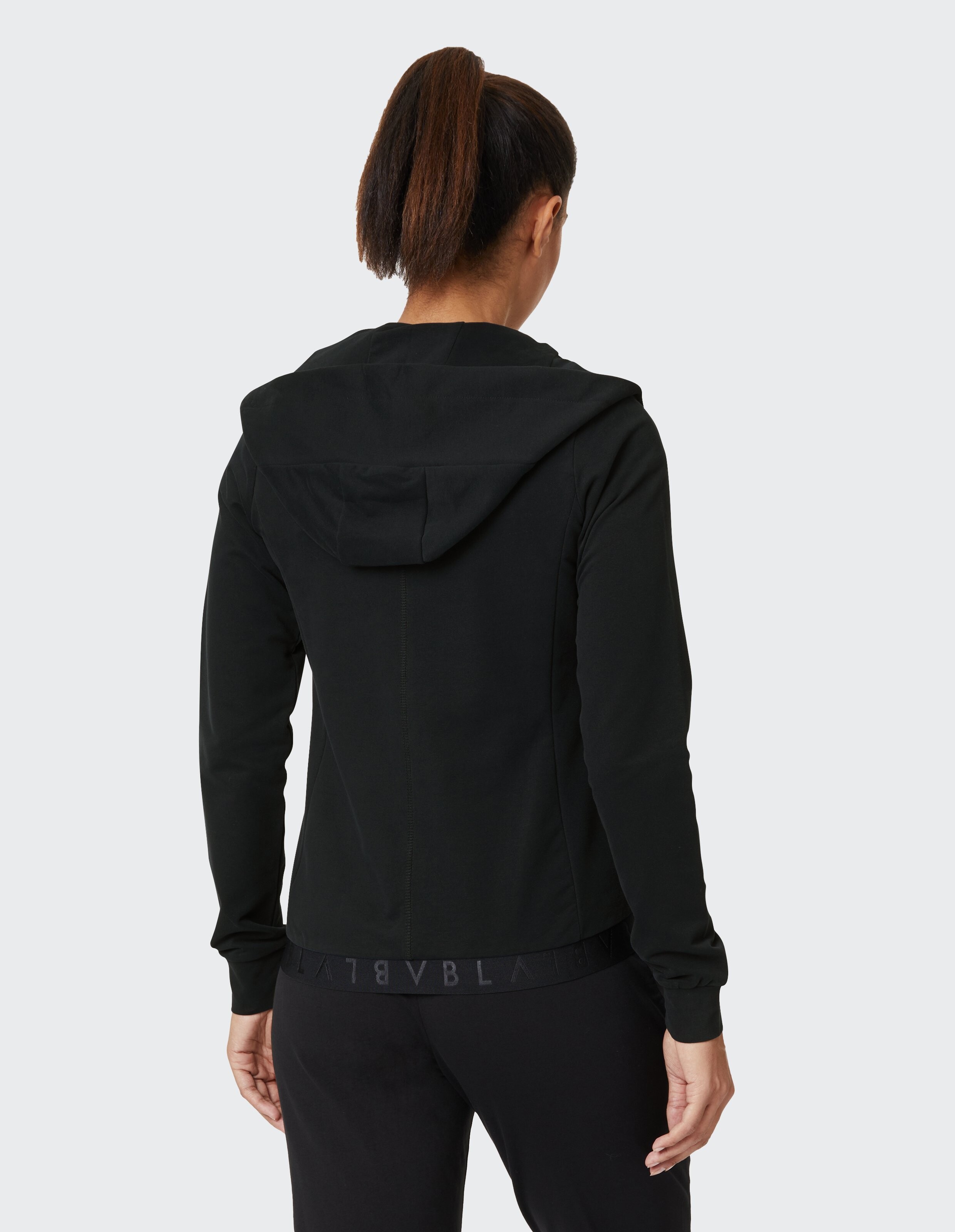 Rückansicht einer Frau in einem schwarzen Kapuzenpullover, perfekt für Freizeitkleidung.