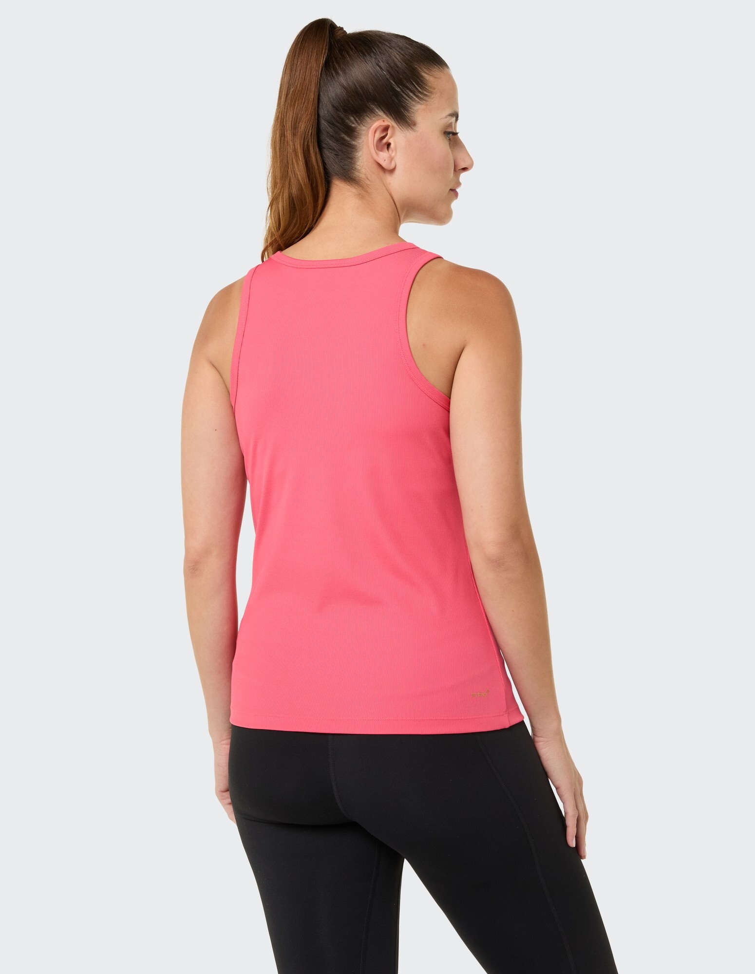 Rückansicht einer Frau in einem rosa Tanktop und schwarzen Leggings, ideal für Freizeitkleidung.