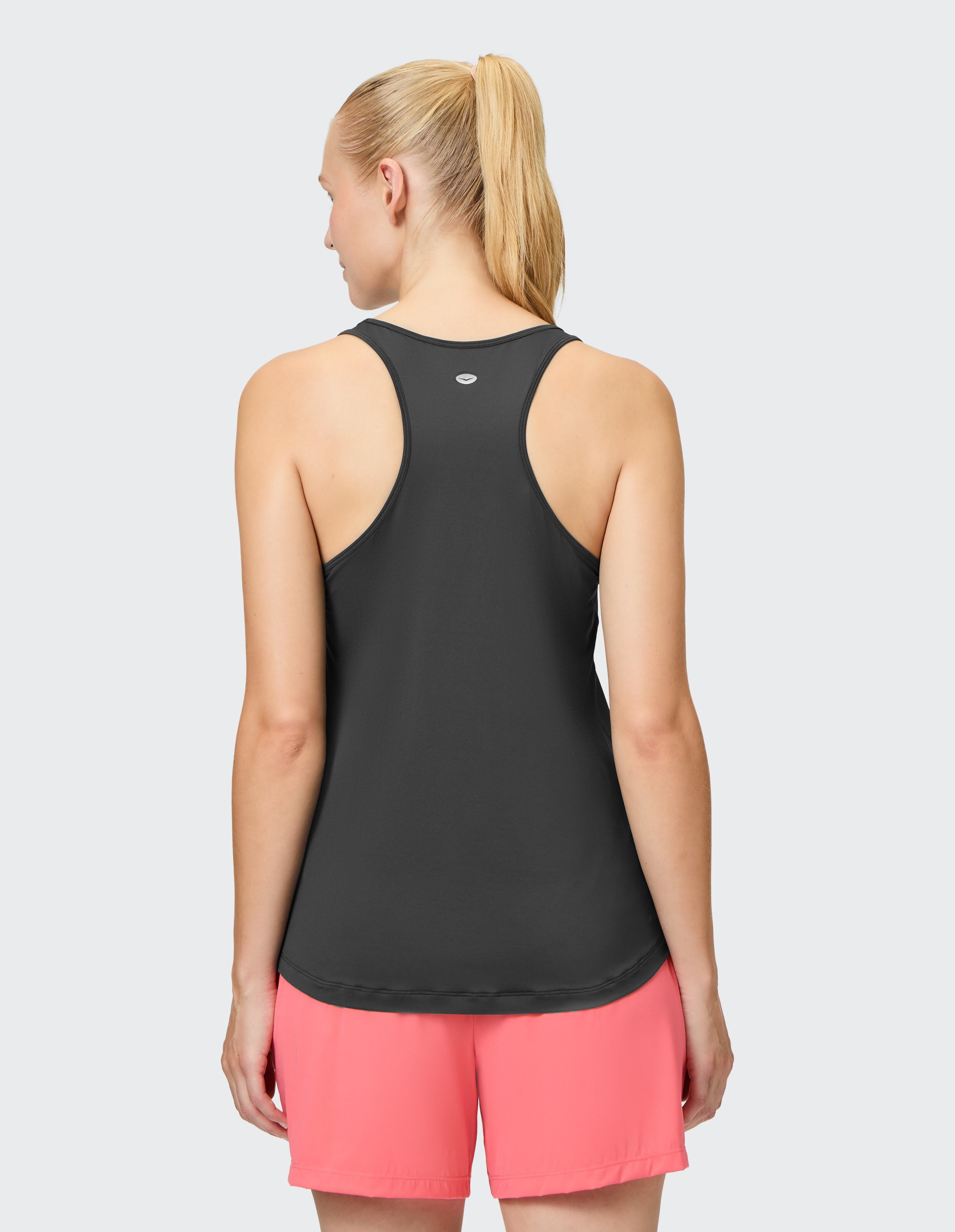 Rückansicht einer Frau in einem schwarzen Tanktop und rosa Shorts, perfekt für Freizeitkleidung.
