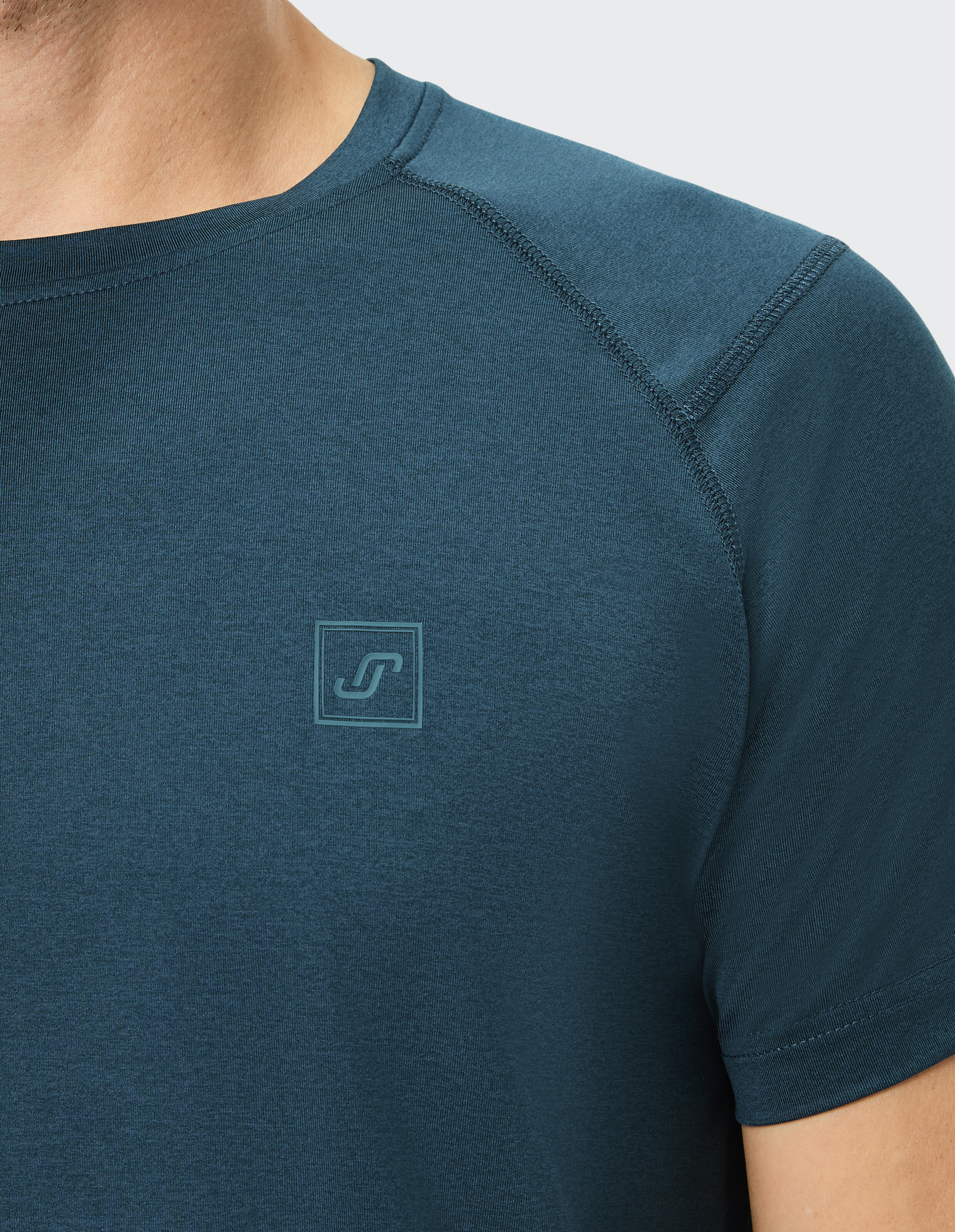 Nahaufnahme eines dunkelgrünen Freizeit-T-Shirts für Herren mit einem Logo auf der Brust.