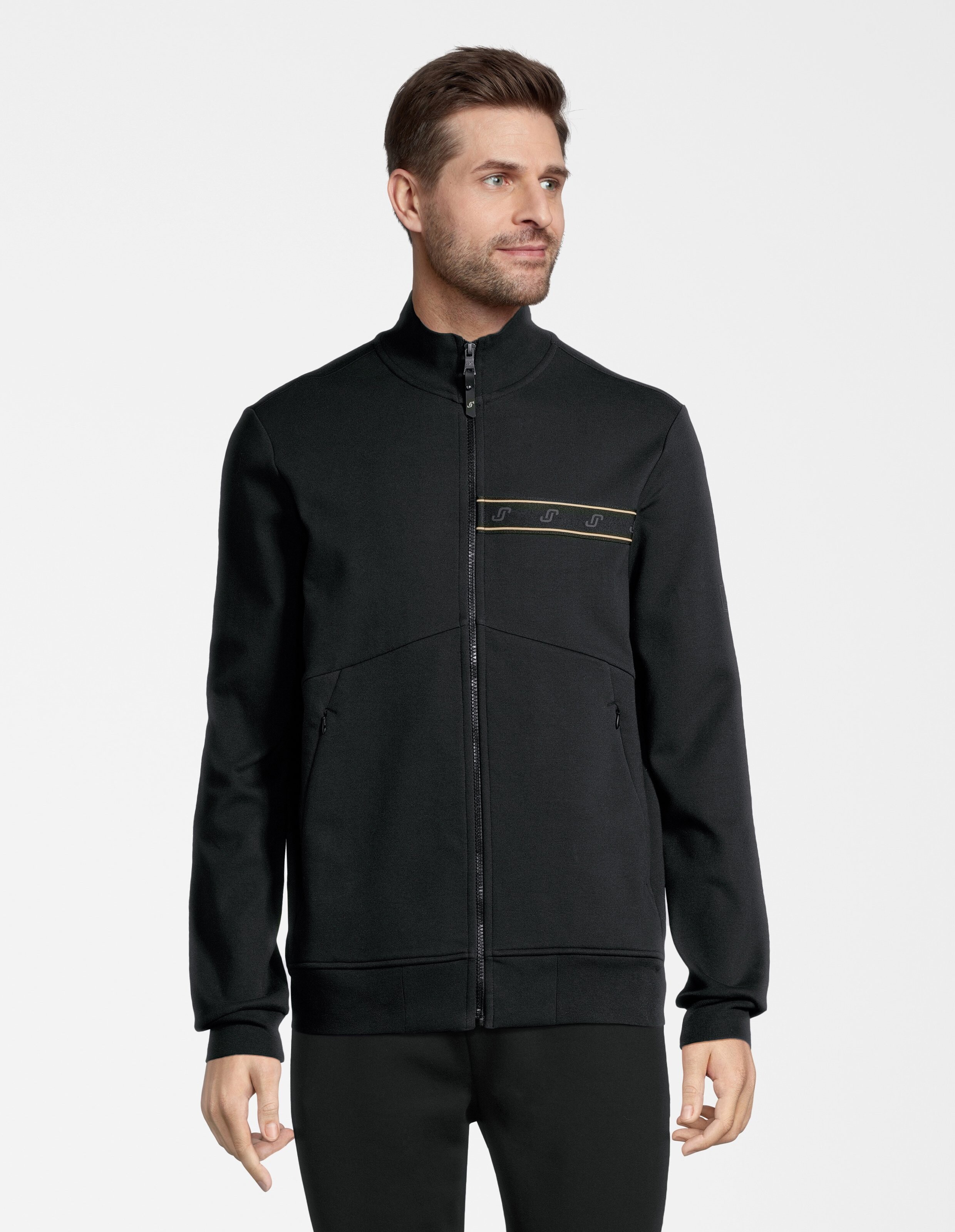 Mann trägt eine schwarze ELBSAND-Trainingsjacke mit Reißverschluss und Logostreifen für lässigen Komfort.