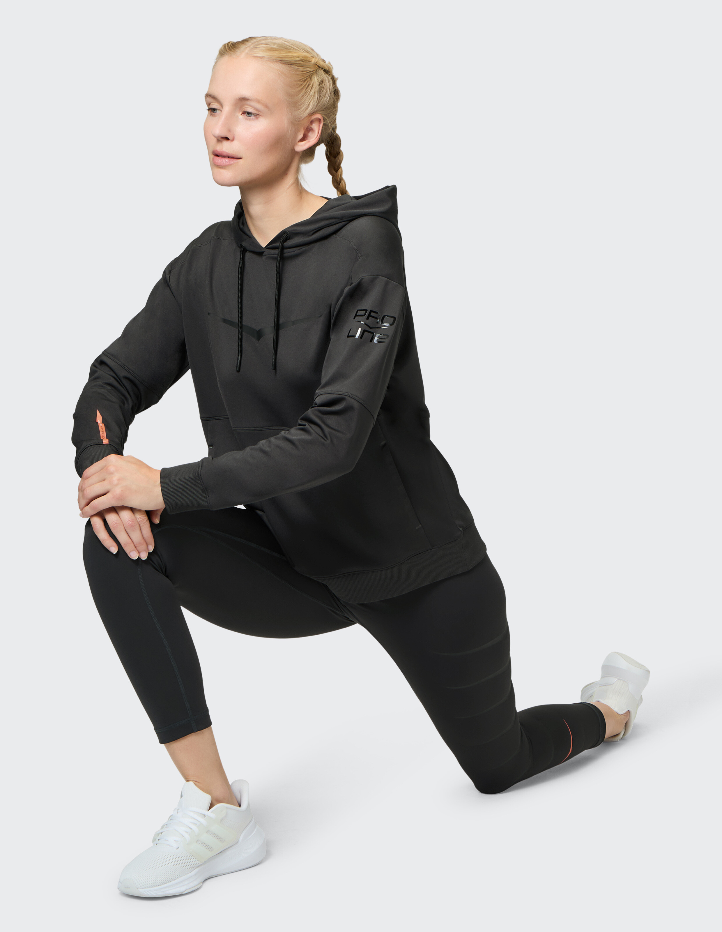 Frau trägt einen schwarzen Venice Beach Hoodie Birmingham für sportliche Freizeitkleidung.