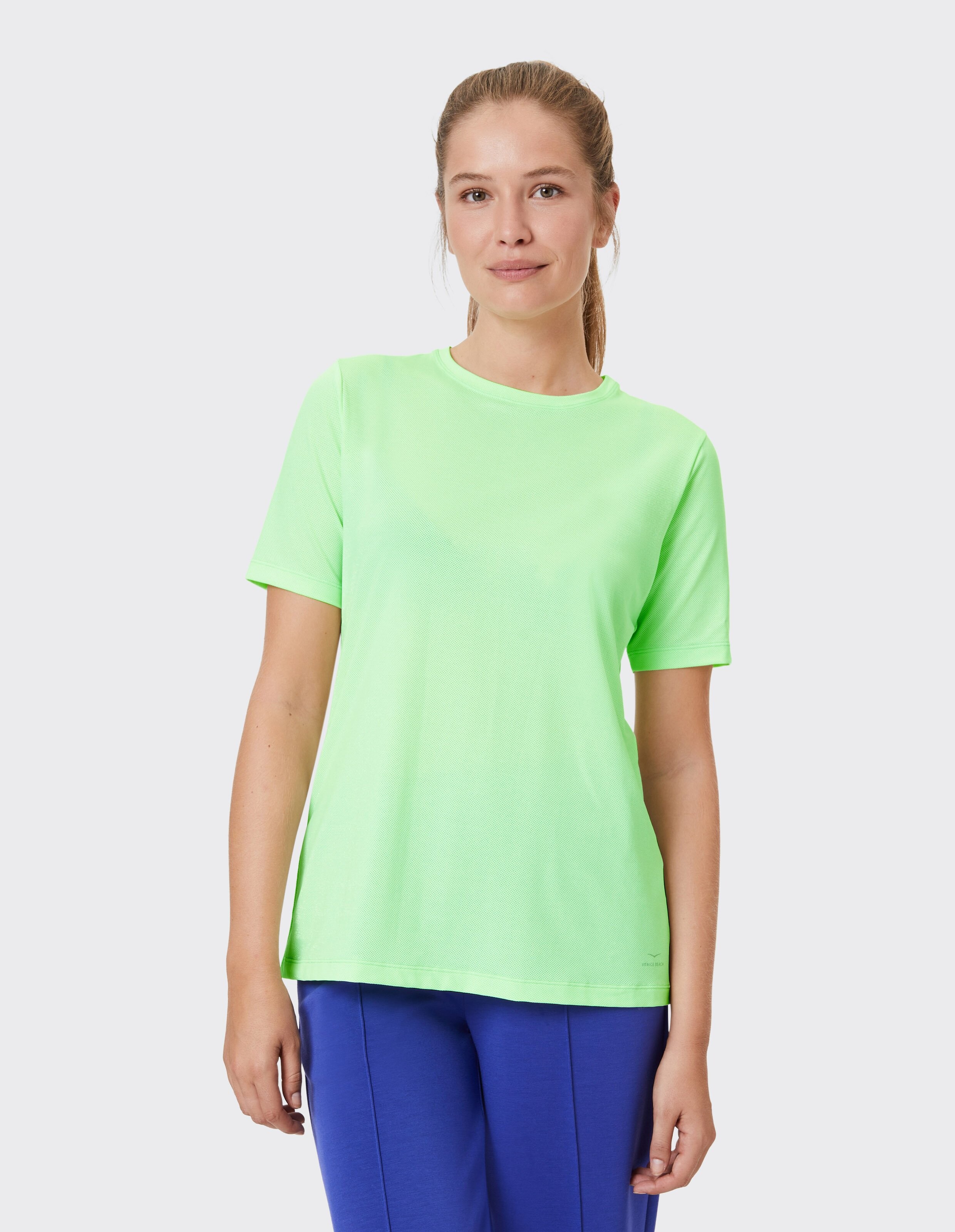 Hellgrünes Kurzarm-T-Shirt für Freizeitkleidung, gepaart mit einer blauen Hose.