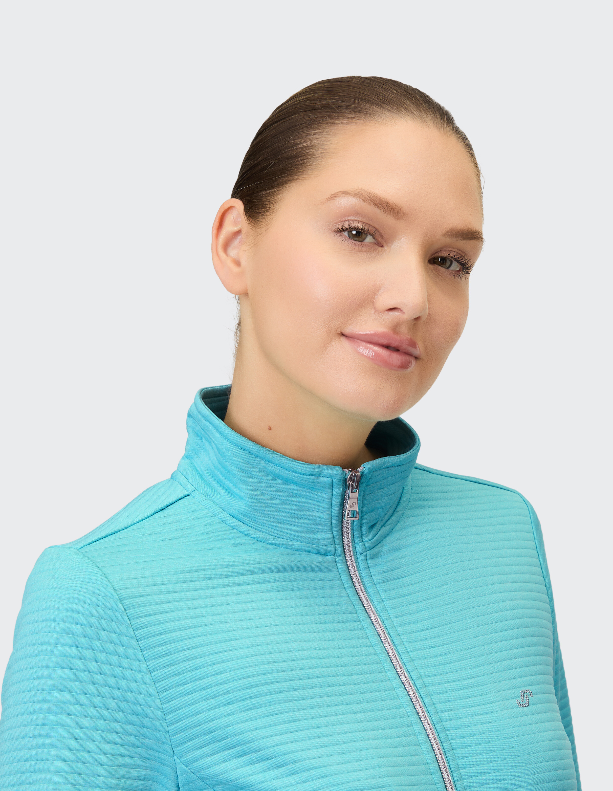 Nahaufnahme einer Frau in einer hellblauen Reißverschlussjacke mit Strukturmuster.