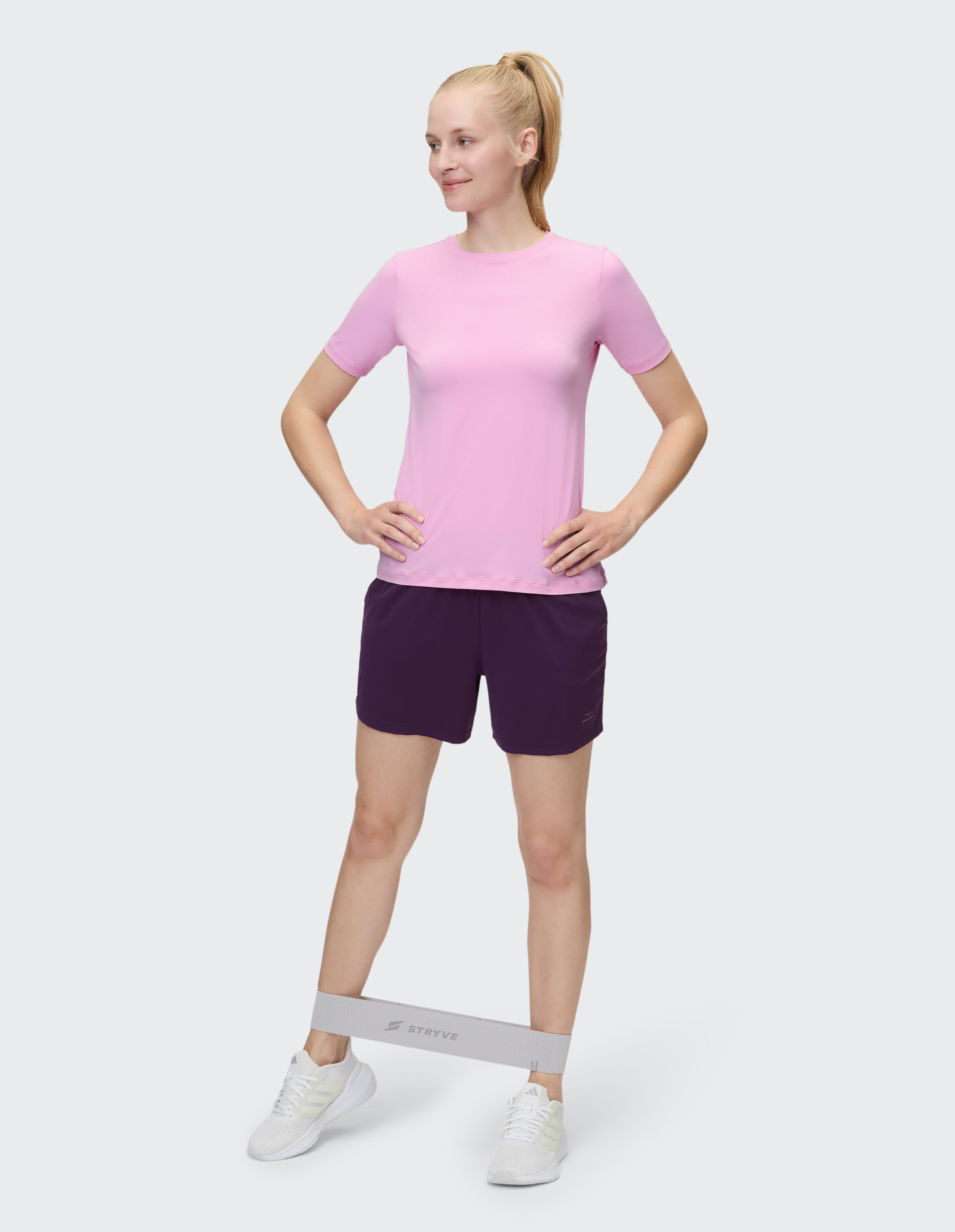 Frau trägt beim Training ein rosafarbenes Venice Beach Kurzarmshirt Sia und dunkle Shorts.