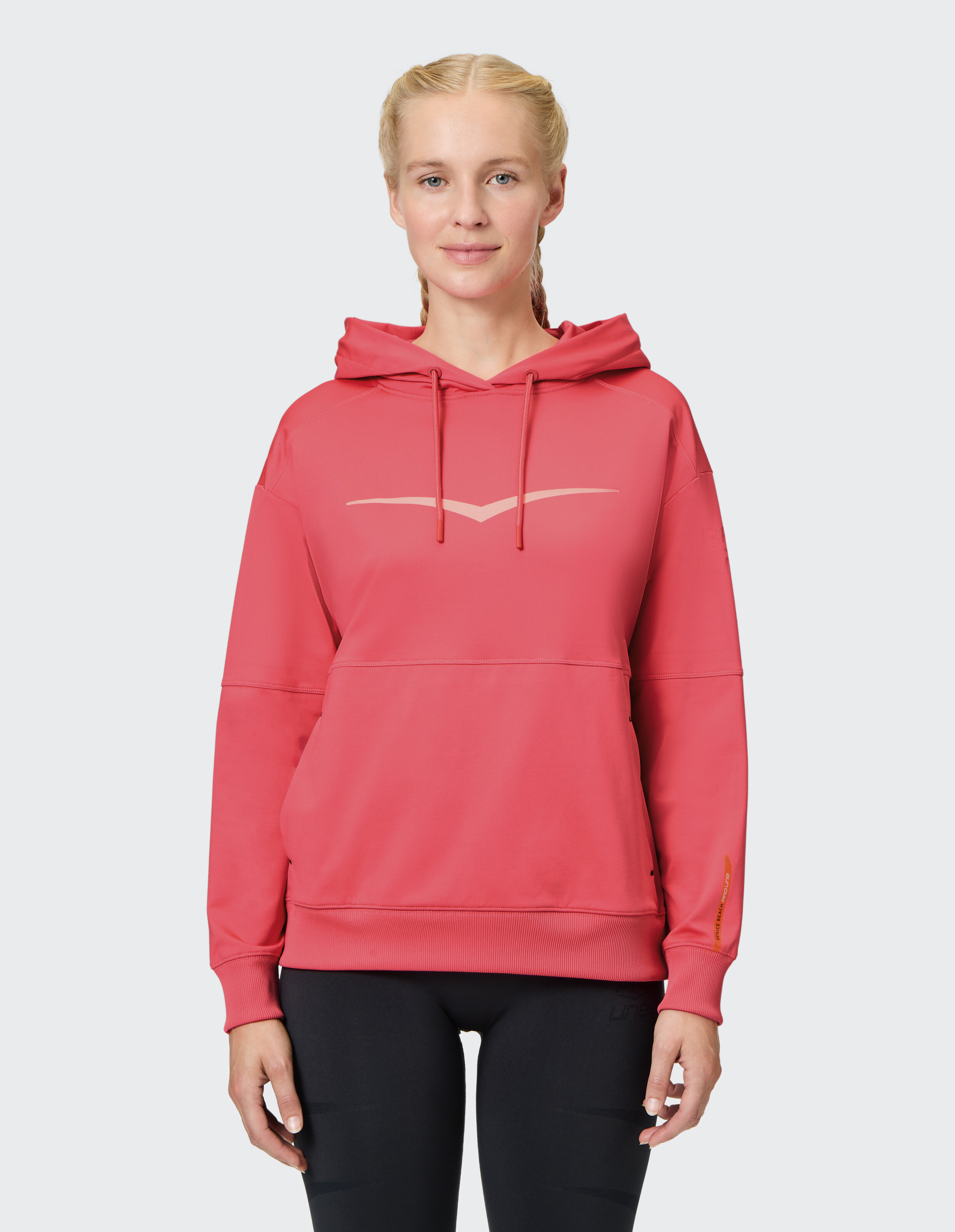 Frau trägt einen kuscheligen rosa Kapuzenpullover mit entspannter Passform, ideal für Freizeitkleidung.