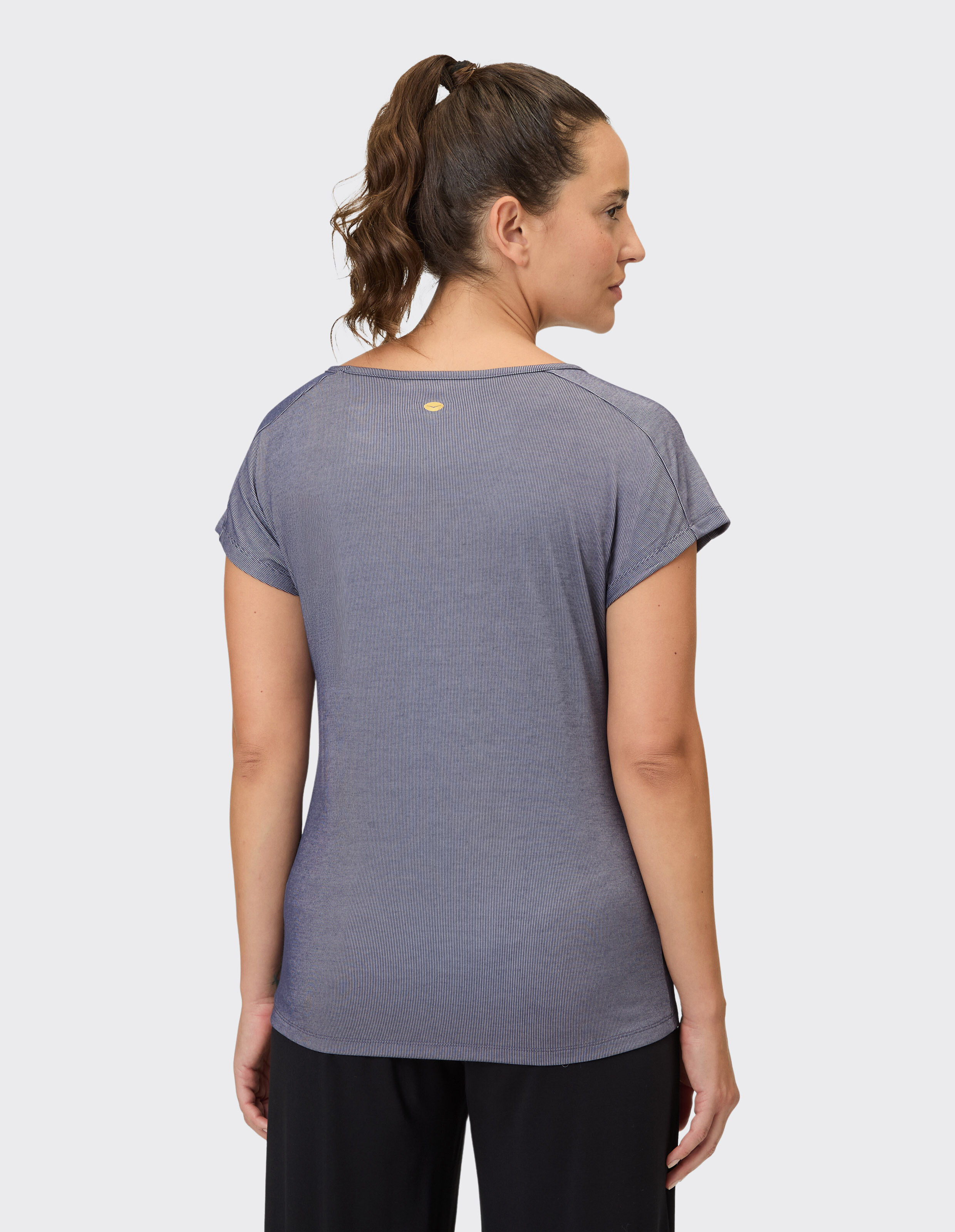 Frau trägt ein gemütliches blaues, kurzärmliges Freizeit-T-Shirt, Rückansicht.