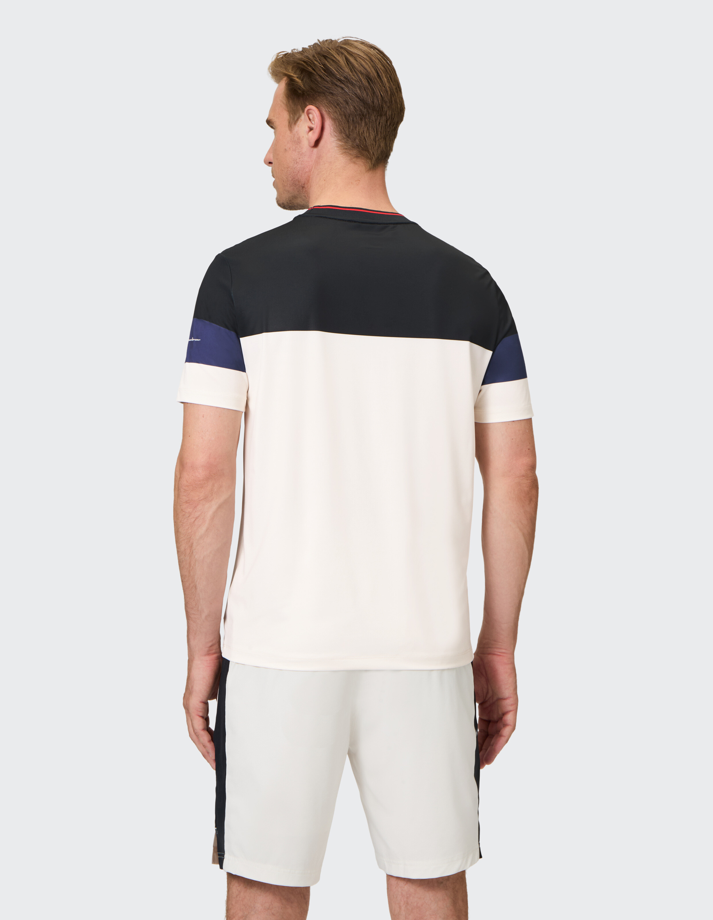 Mann trägt ein lässiges Farbblock-T-Shirt und passende Shorts für einen stilvollen Lounge-Look.