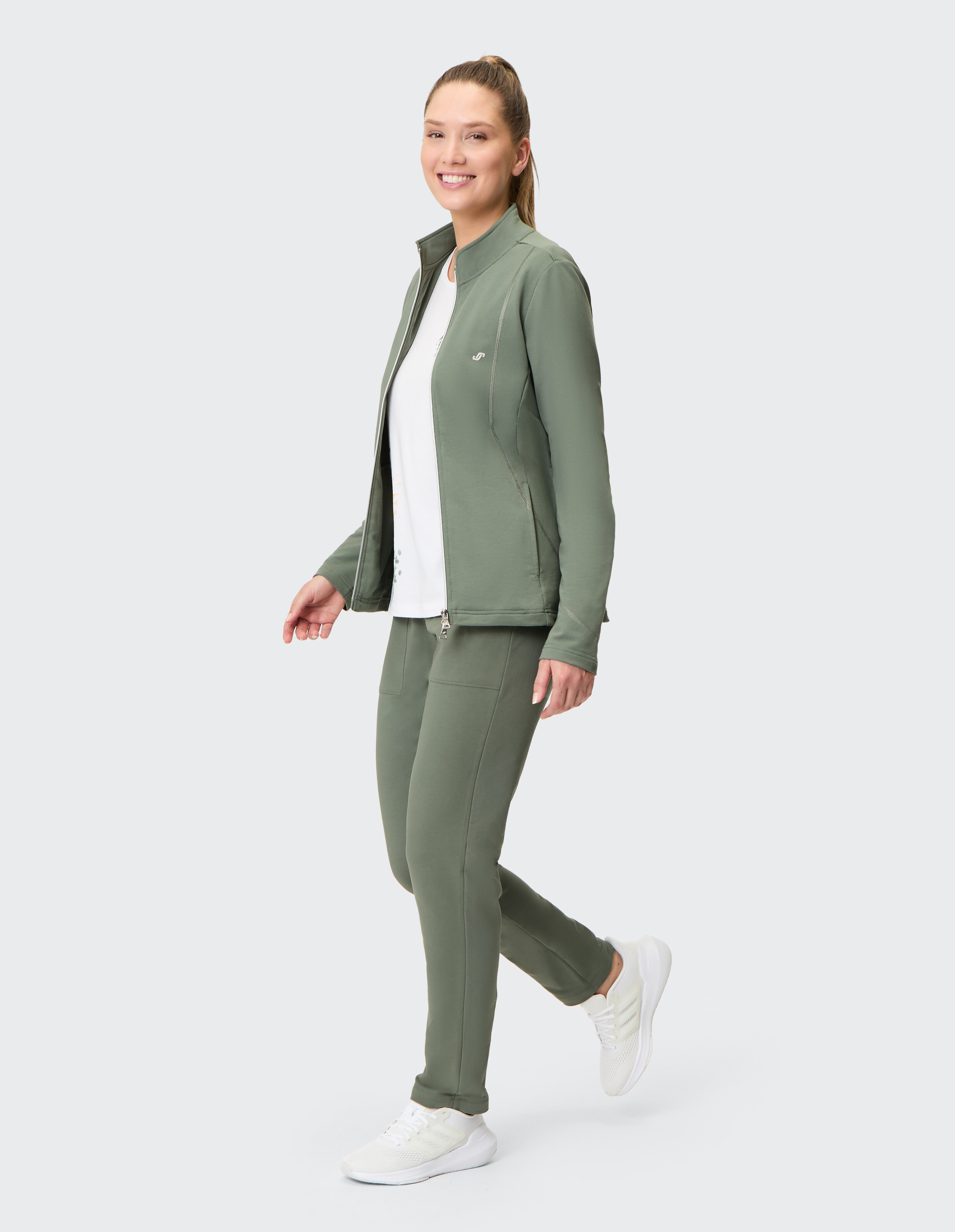 Dunkelgrüne Damenjacke mit Reißverschluss und Stehkragen, dezentem Logo auf der Brust und zwei seitlichen Nähten als Design-Elemente.