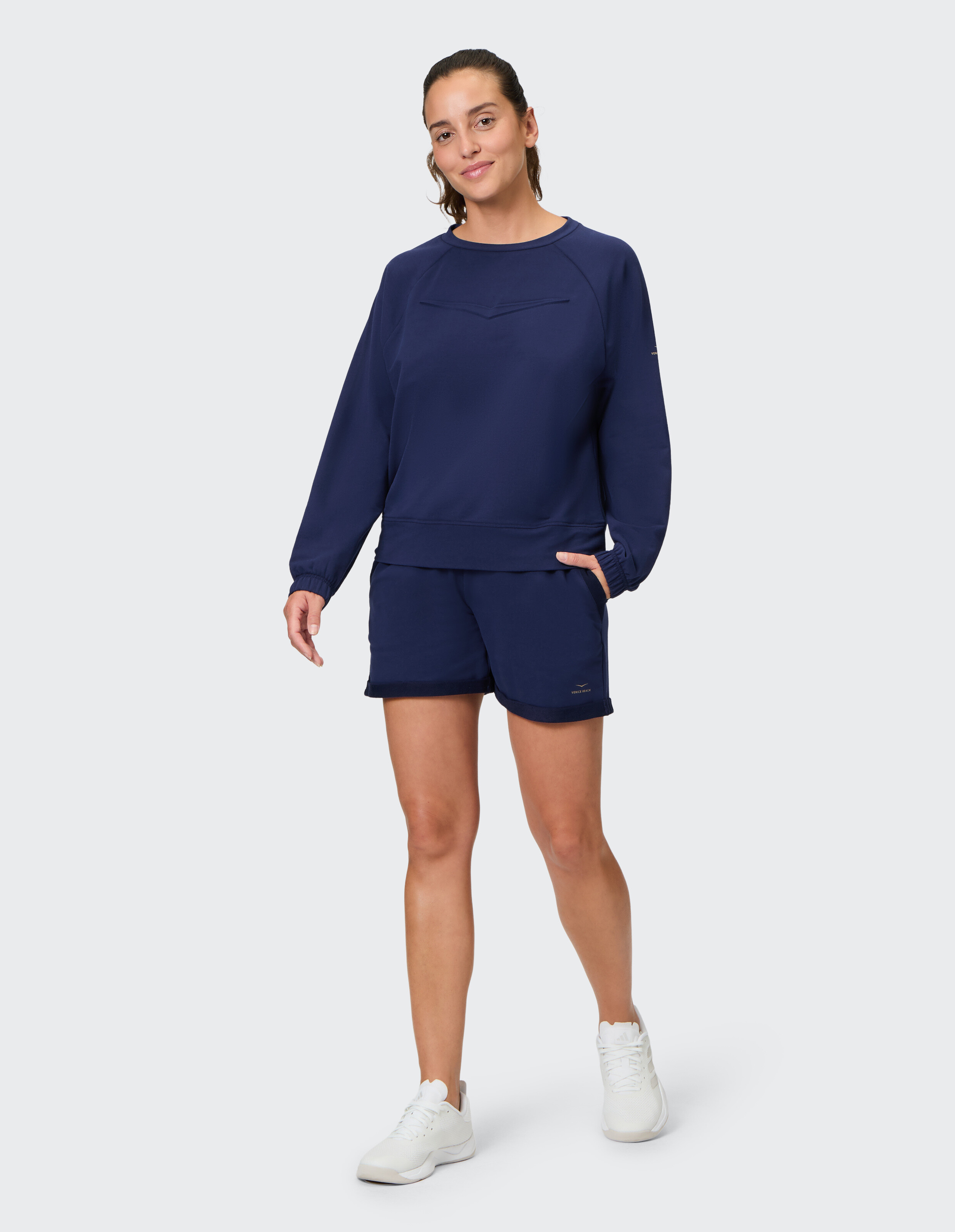 Frau in dunkelblauem, lässigem Sweatshirt und Shorts, perfekt zum Faulenzen oder Brunch.