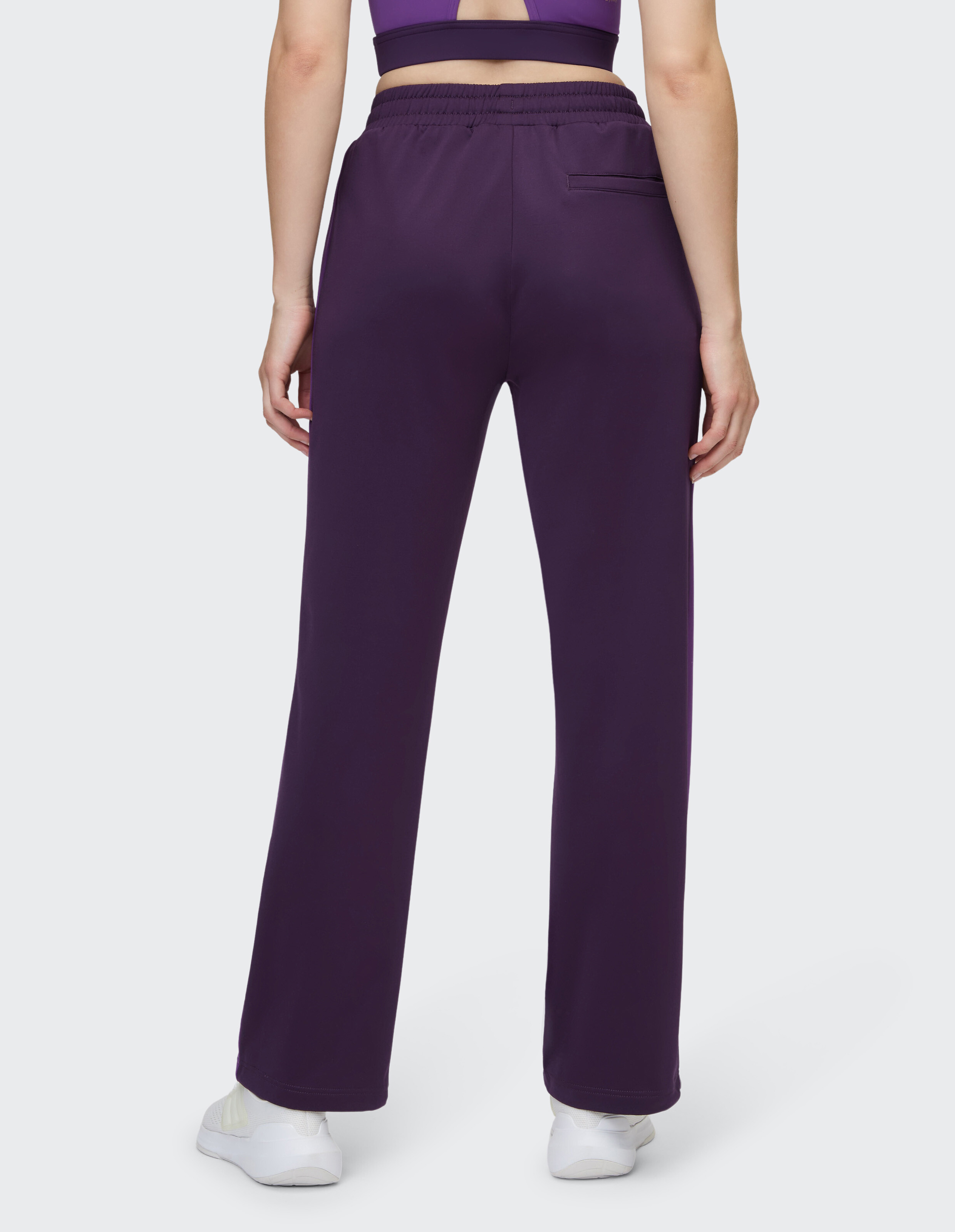 Rückansicht einer lila Freizeithose mit elastischem Bund und Seitentasche.