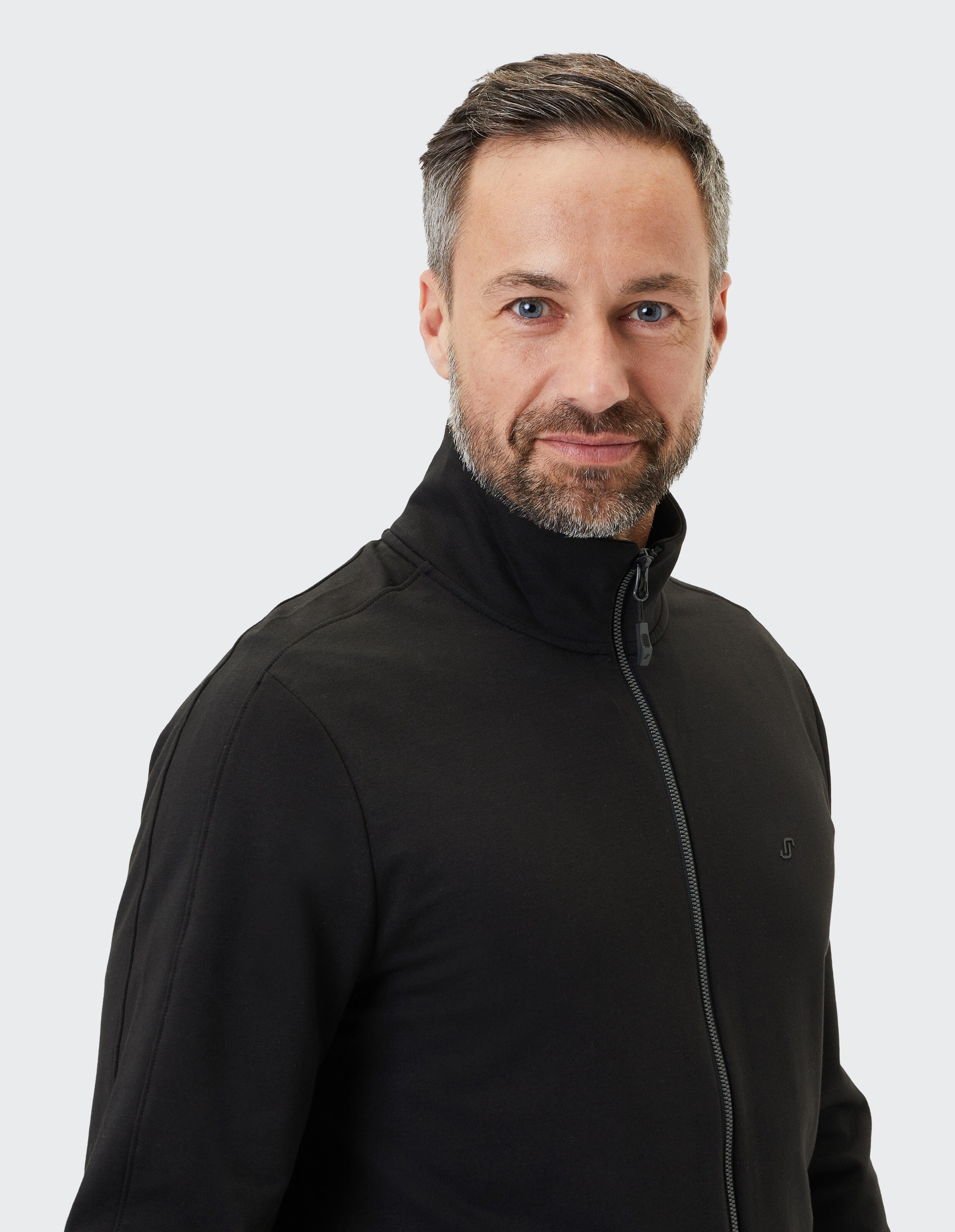 Schwarze Jacke mit Stehkragen, Frontreißverschluss und zwei Seitentaschen, schlichtes Design, ideal für kühle Tage.