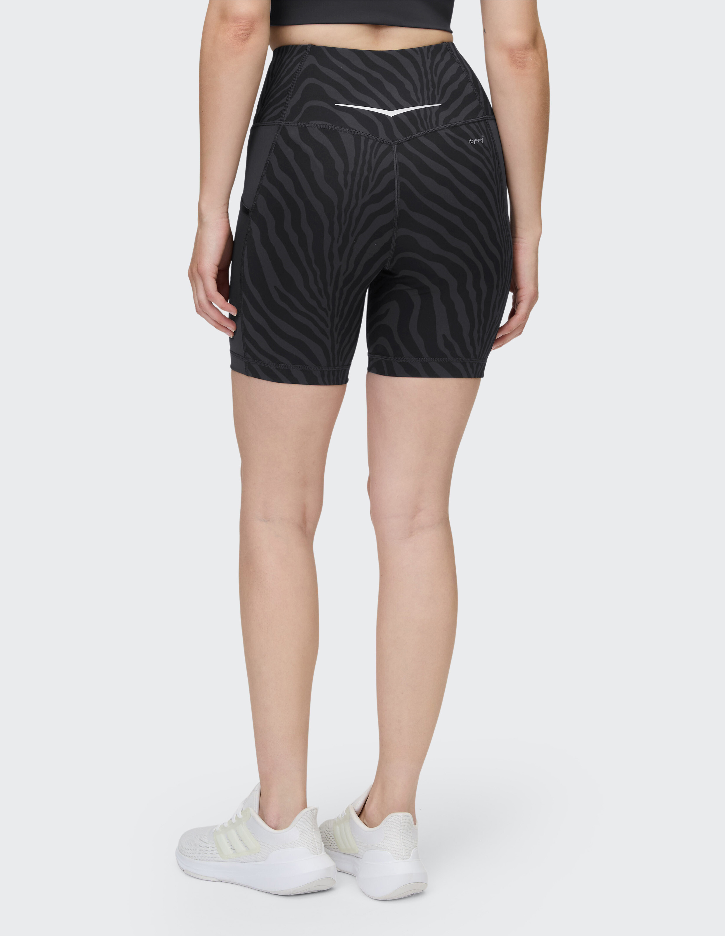 Frau trägt schwarze sportliche Bikershorts mit hoher Taille und Zebramuster für Freizeitkleidung.