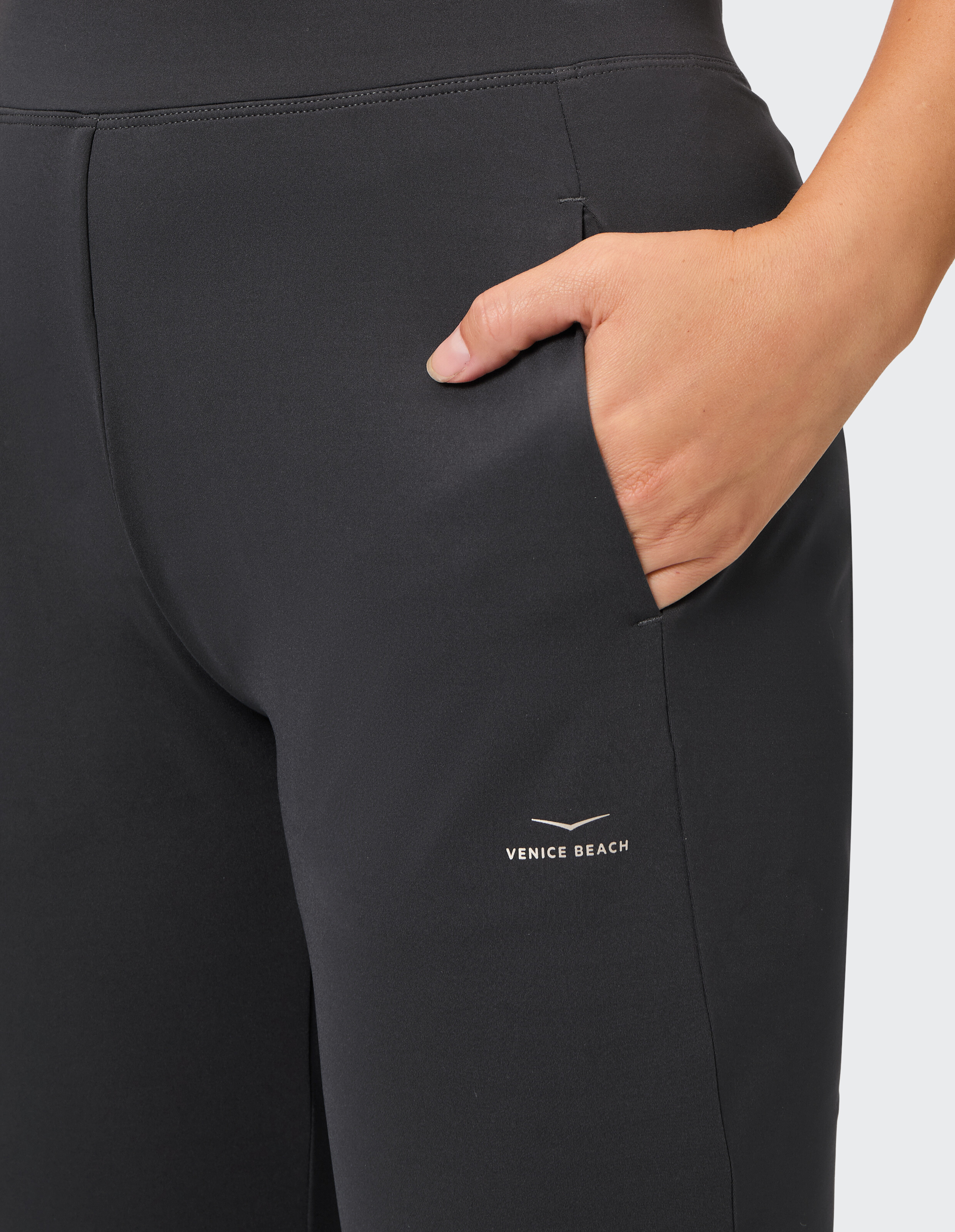 Nahaufnahme einer schwarzen Freizeithose mit Seitentasche und Venice Beach-Logo.