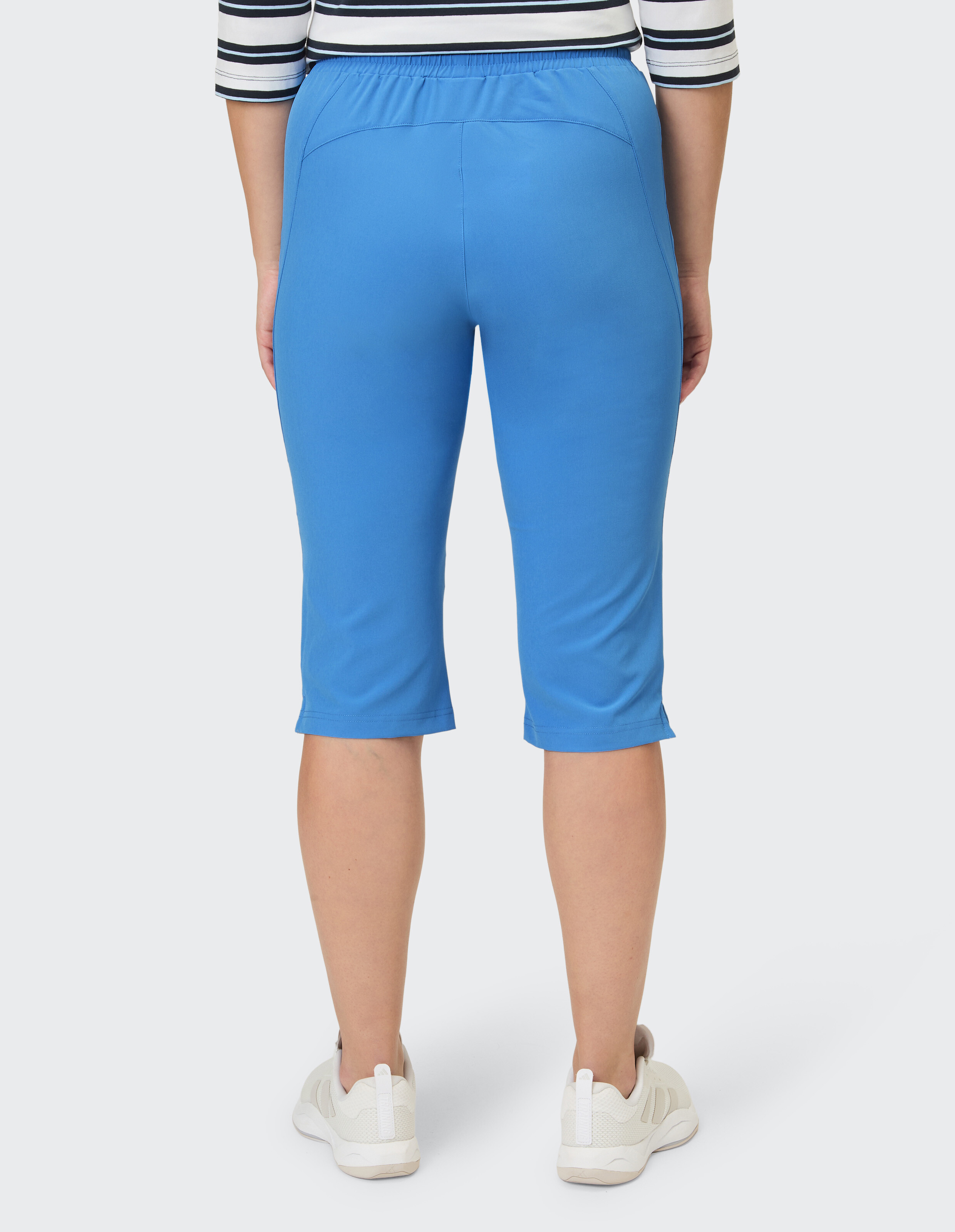 Rückansicht einer Frau in blauen Caprihosen, perfekt für Freizeitkleidung.
