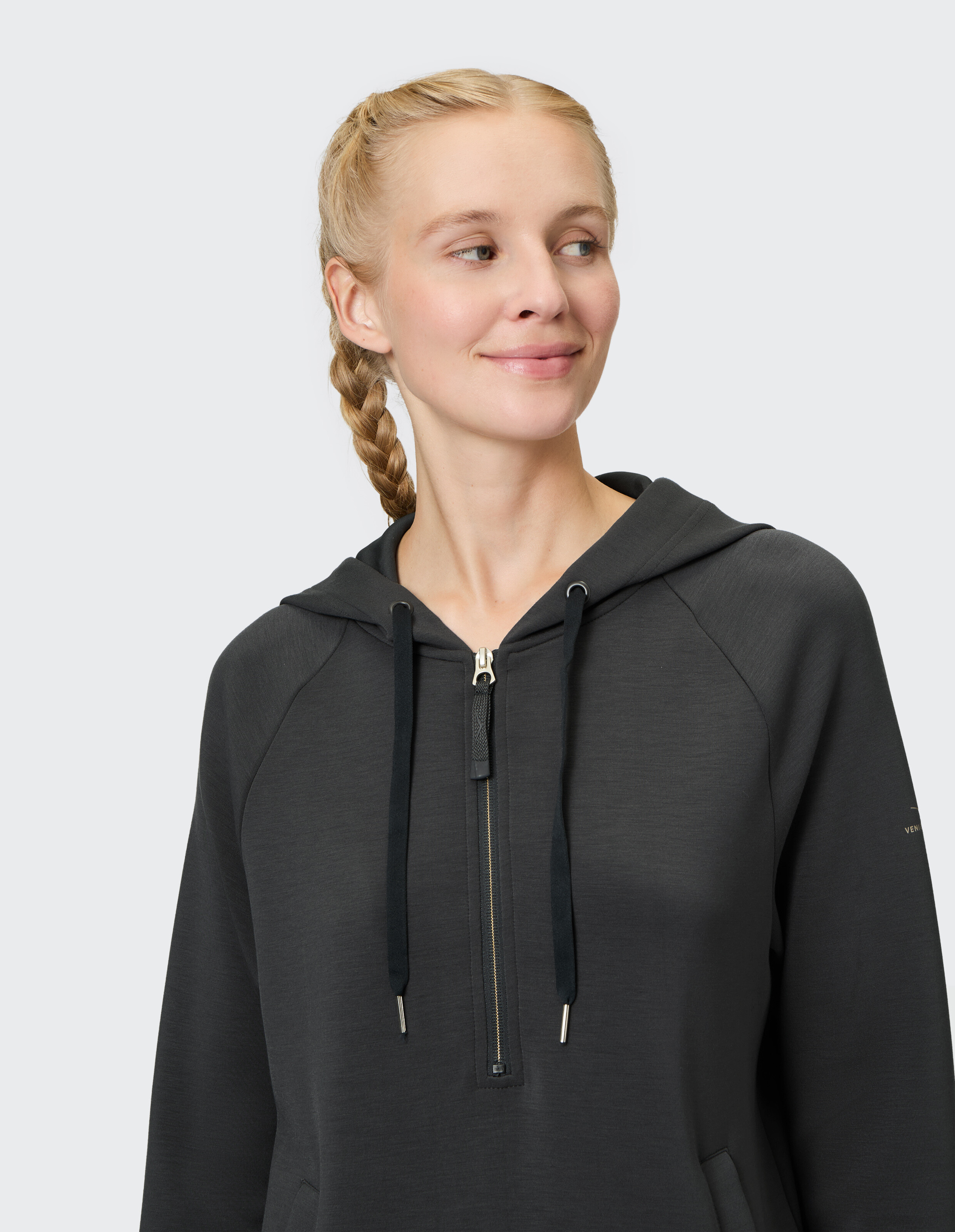 Frau trägt einen schwarzen Venice Beach Halfzip-Hoodie Jessica für gemütlichen Casual-Style.