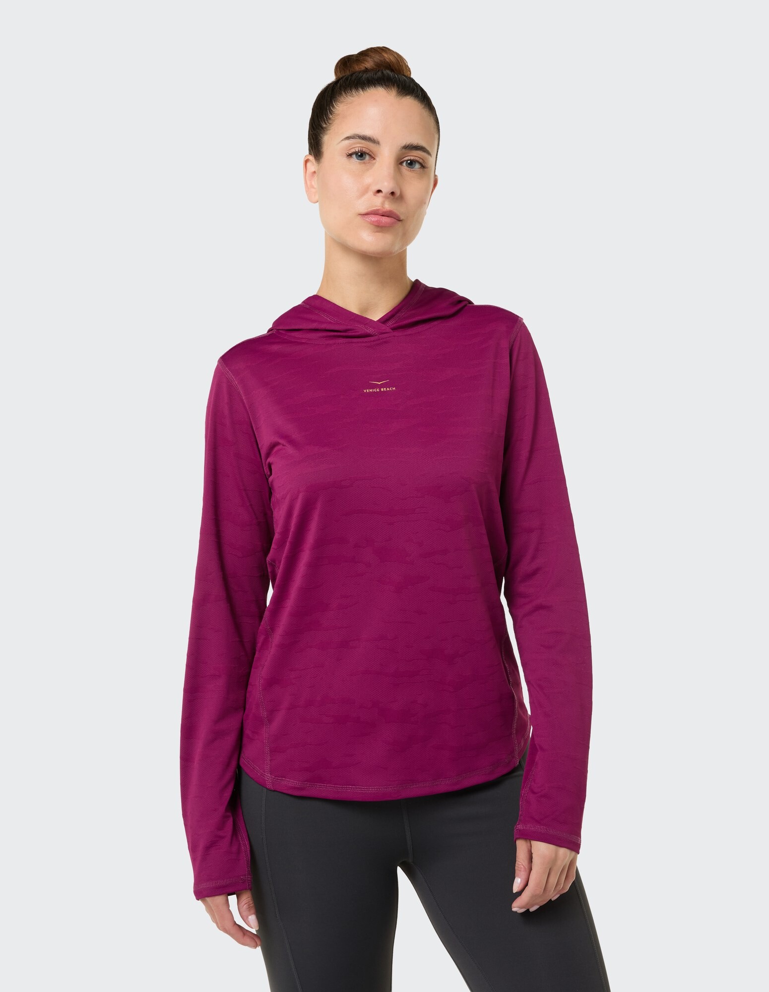 Frau trägt ein gemütliches lilafarbenes Langarmshirt mit Kapuze, perfekt für Freizeitausflüge.