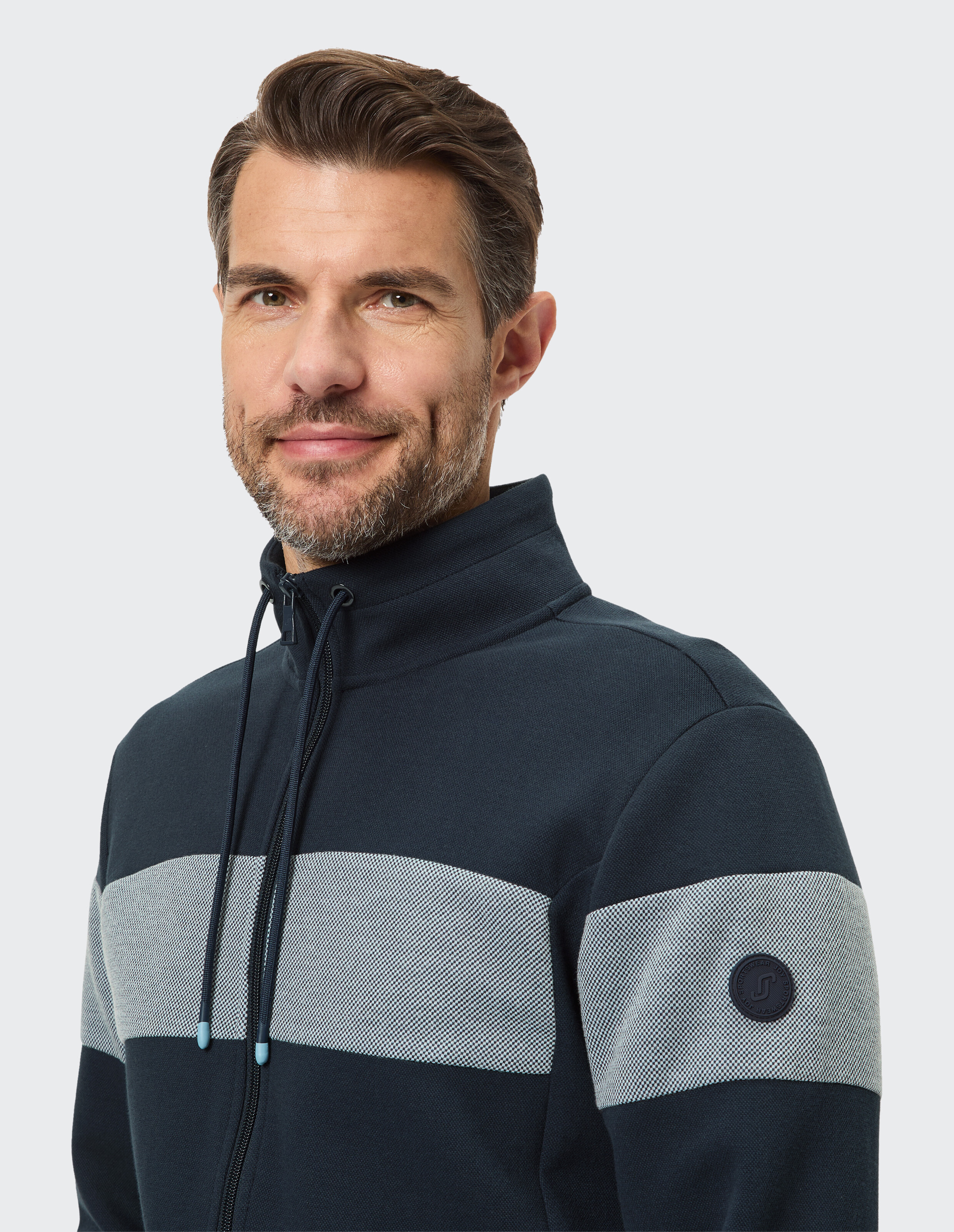 Marineblaue Herrenjacke mit Reißverschluss, grauem Streifendesign und Logo-Detail.