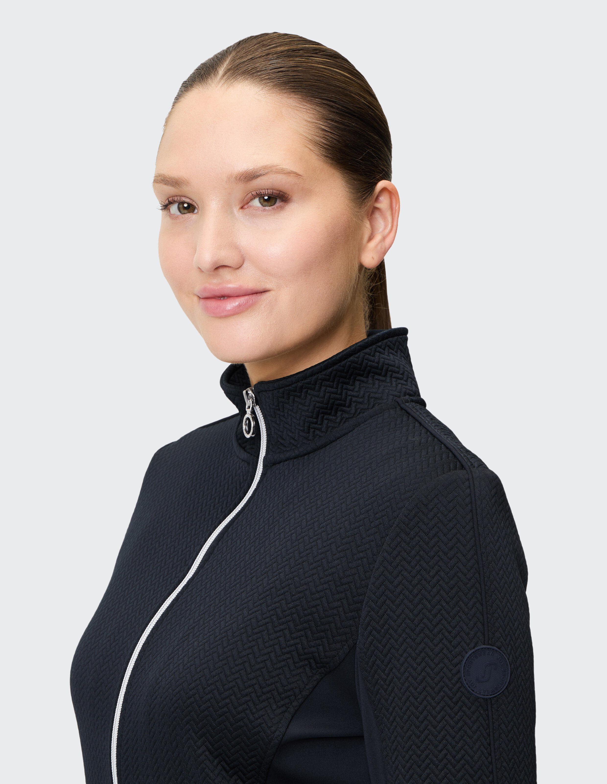 Frau trägt eine marineblaue, strukturierte Jacke mit Reißverschluss für einen gemütlichen, lässigen Stil.