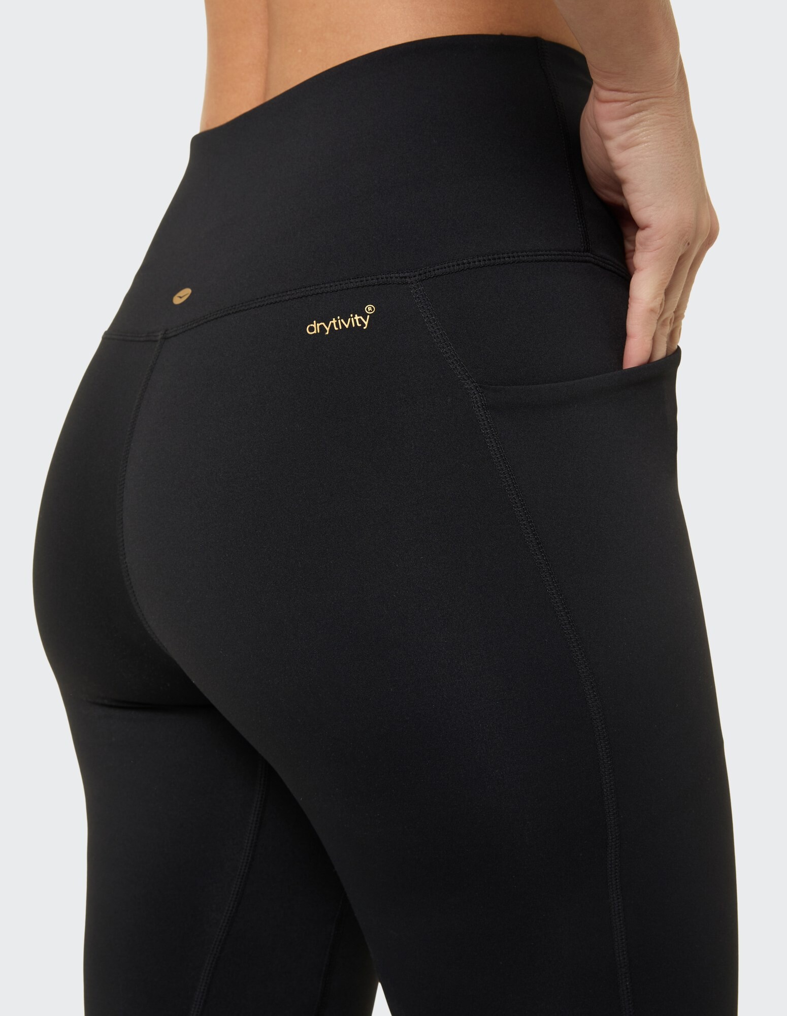Nahaufnahme einer schwarzen Leggings mit Tasche und drytivity-Logo, ideal für Freizeitkleidung.