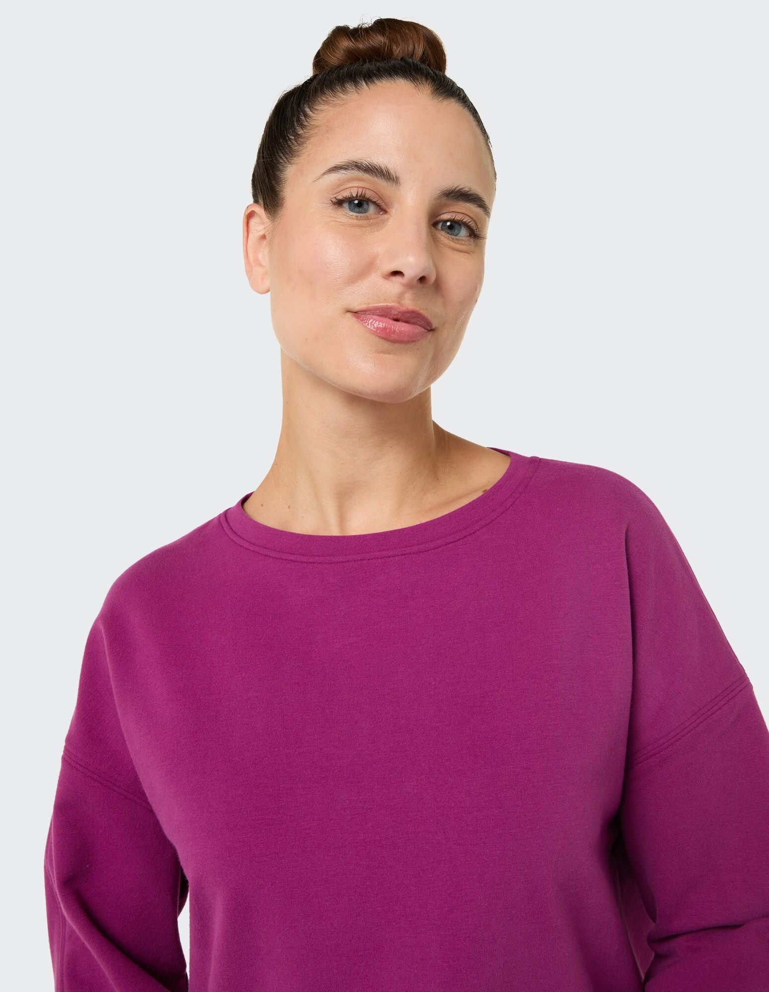 Frau in einem gemütlichen lila Sweatshirt, das eine entspannte Passform und einen lässigen Stil zeigt.