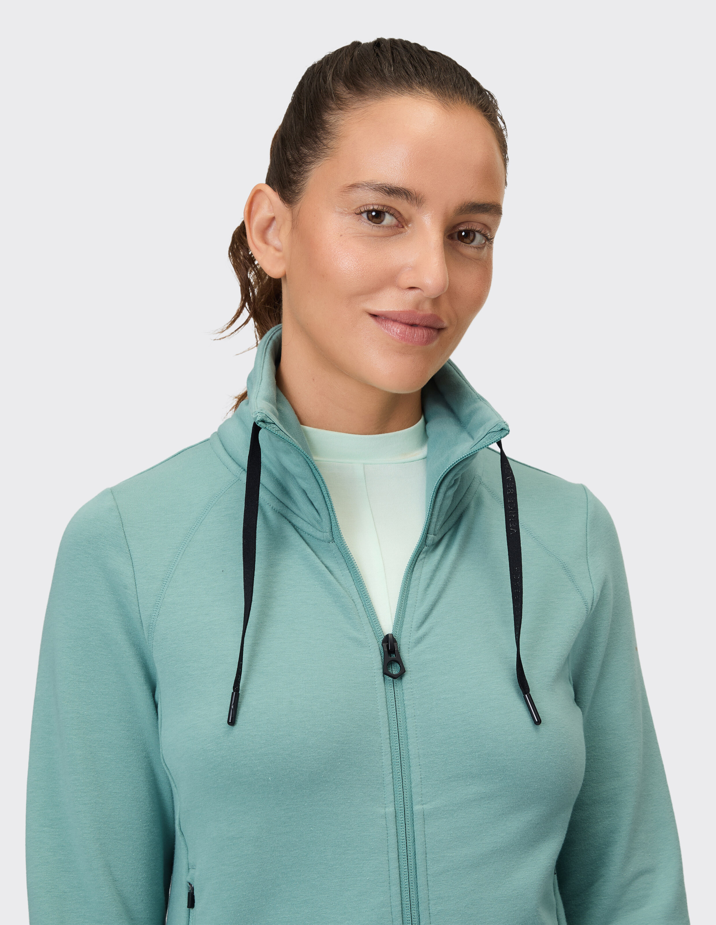 Frau trägt eine gemütliche blaugrüne Venice Beach Sweatjacke Florence mit hohem Kragen.