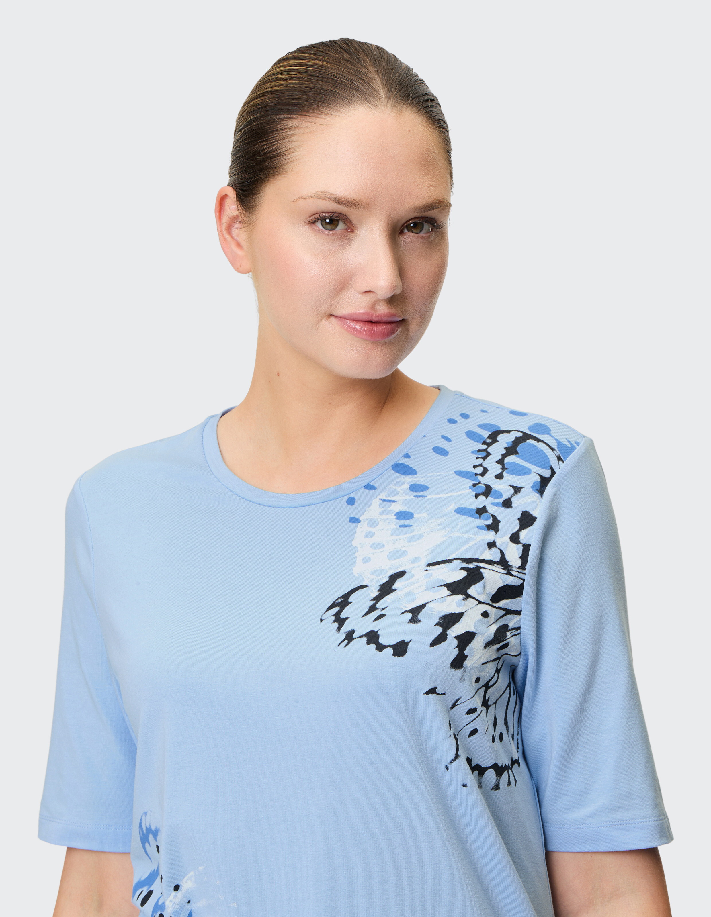 Hellblaues, lässiges T-Shirt mit kunstvollem Schmetterlingsdruck, perfekt für entspannte Ausflüge.