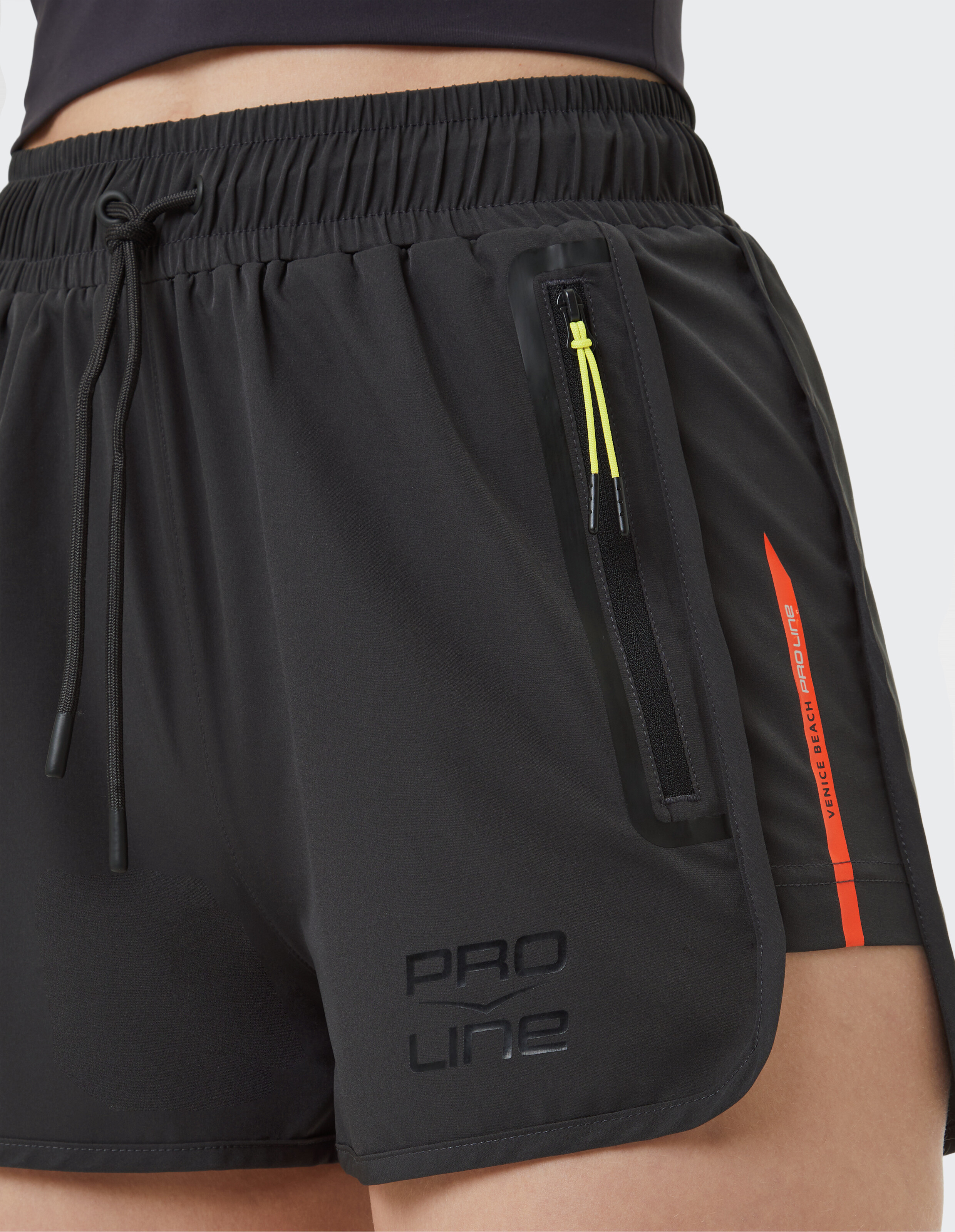 Nahaufnahme einer schwarzen Sportshorts mit Taschen und Logo, ideal für Freizeitkleidung.