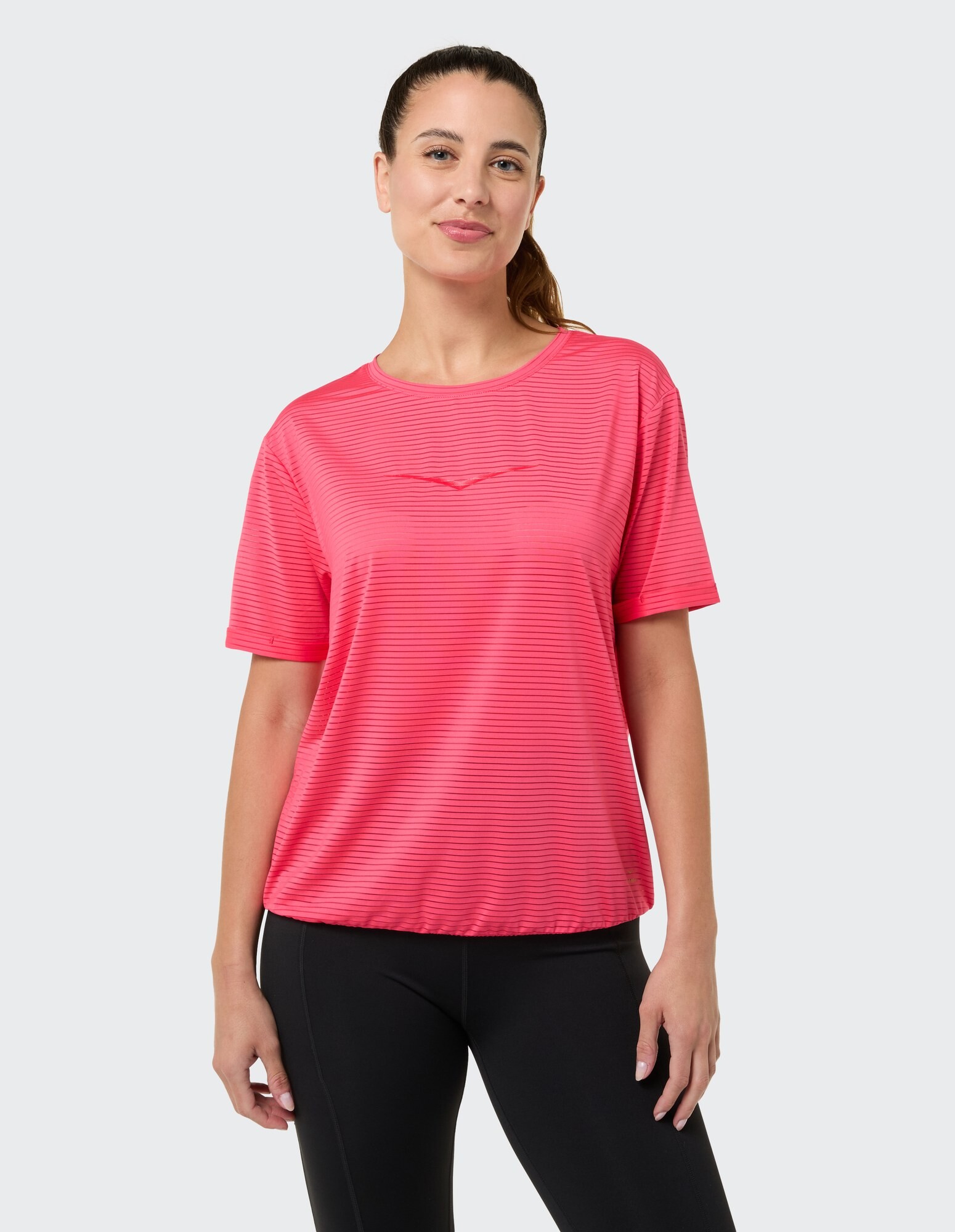 Frau in einem rosa gestreiften Freizeit-T-Shirt, perfekt zum Faulenzen oder Brunch.