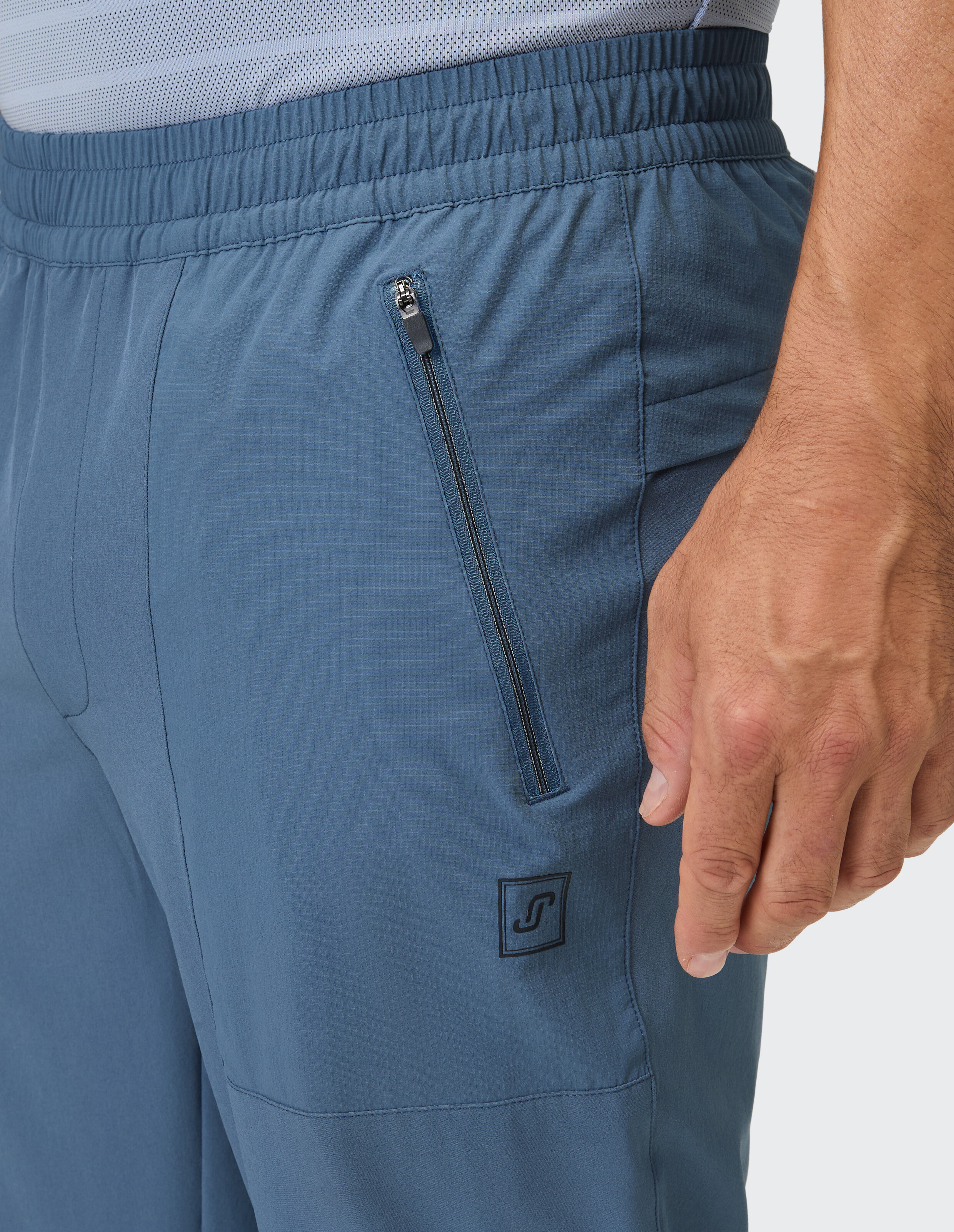 Blaue Shorts mit geripptem Bund und einer diagonalen Reißverschlusstasche.