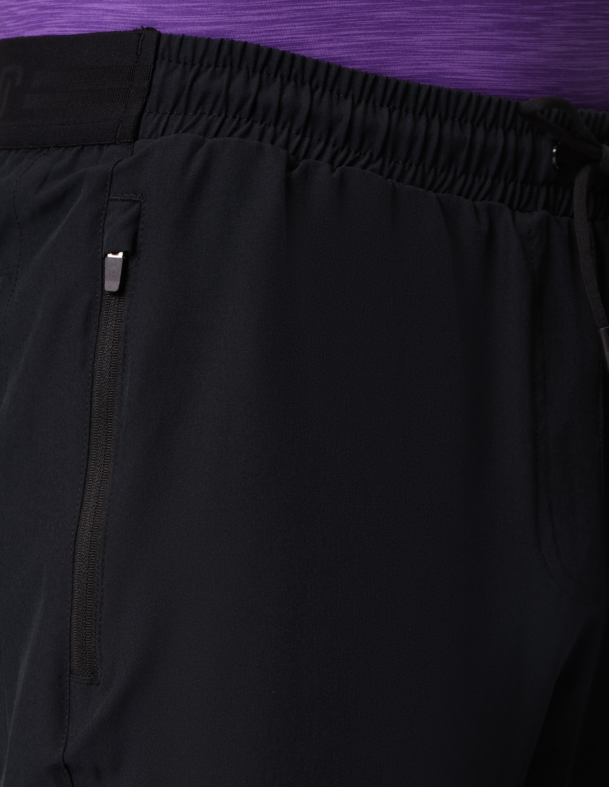 Nahaufnahme einer schwarzen Freizeithose mit elastischem Bund und seitlicher Reißverschlusstasche.