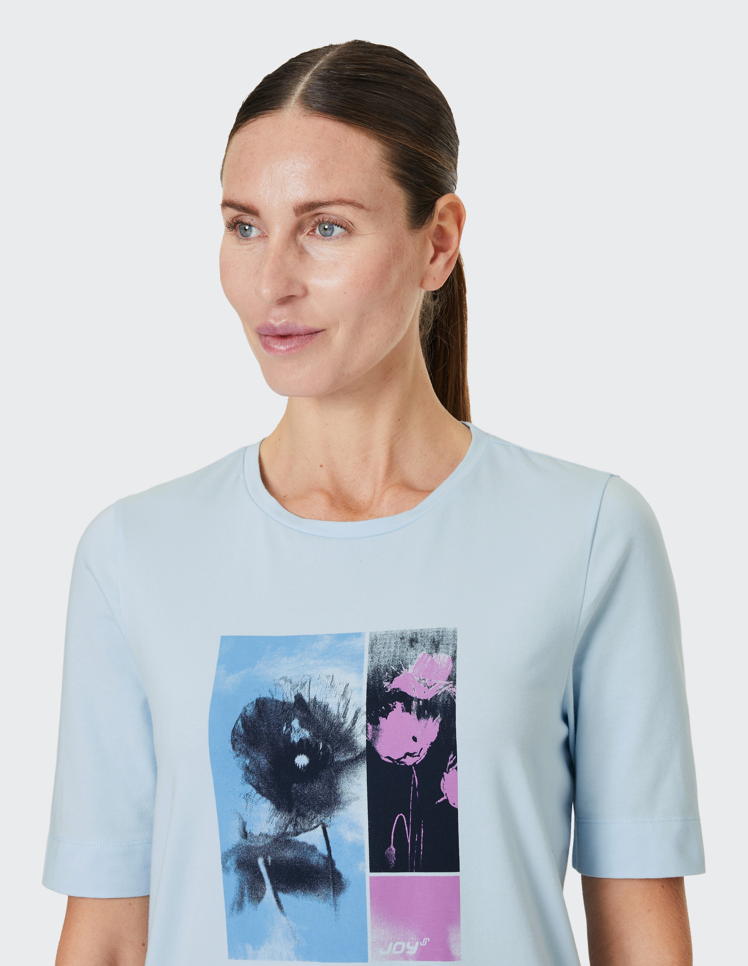 Hellblaues T-Shirt mit zweigeteiltem Kunstmotiv; links blaues Blumenbild, rechts rosa abstraction, darunter der Schriftzug \\\\\\\\\\\\\\\\\\\\\\\\\\\\\\\"Joy\\\\\\\\\\\\\\\\\\\\\\\\\\\\\\\""."