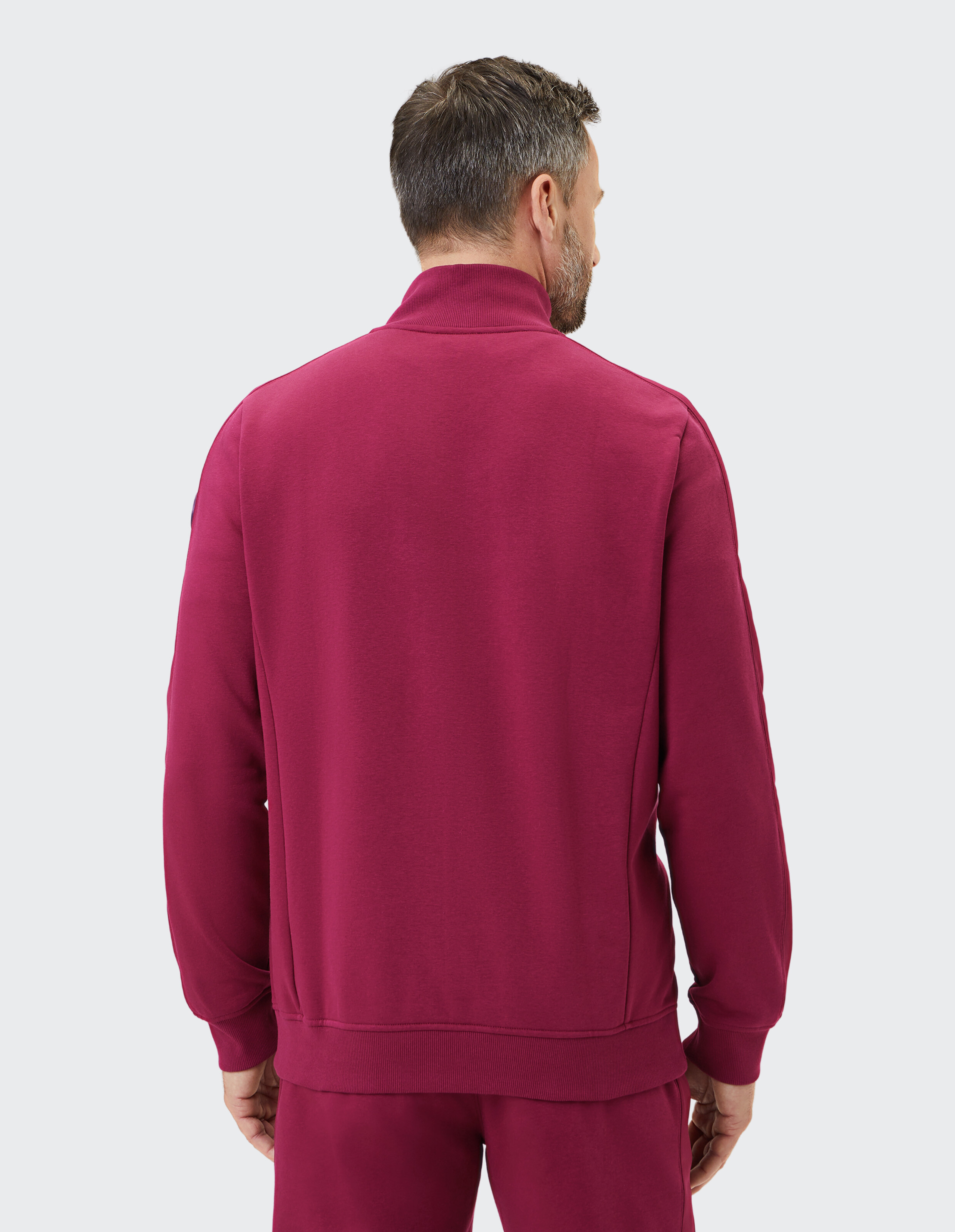 Rückansicht eines Mannes in einem burgunderfarbenen Freizeit-Sweatshirt, perfekt zum Entspannen.