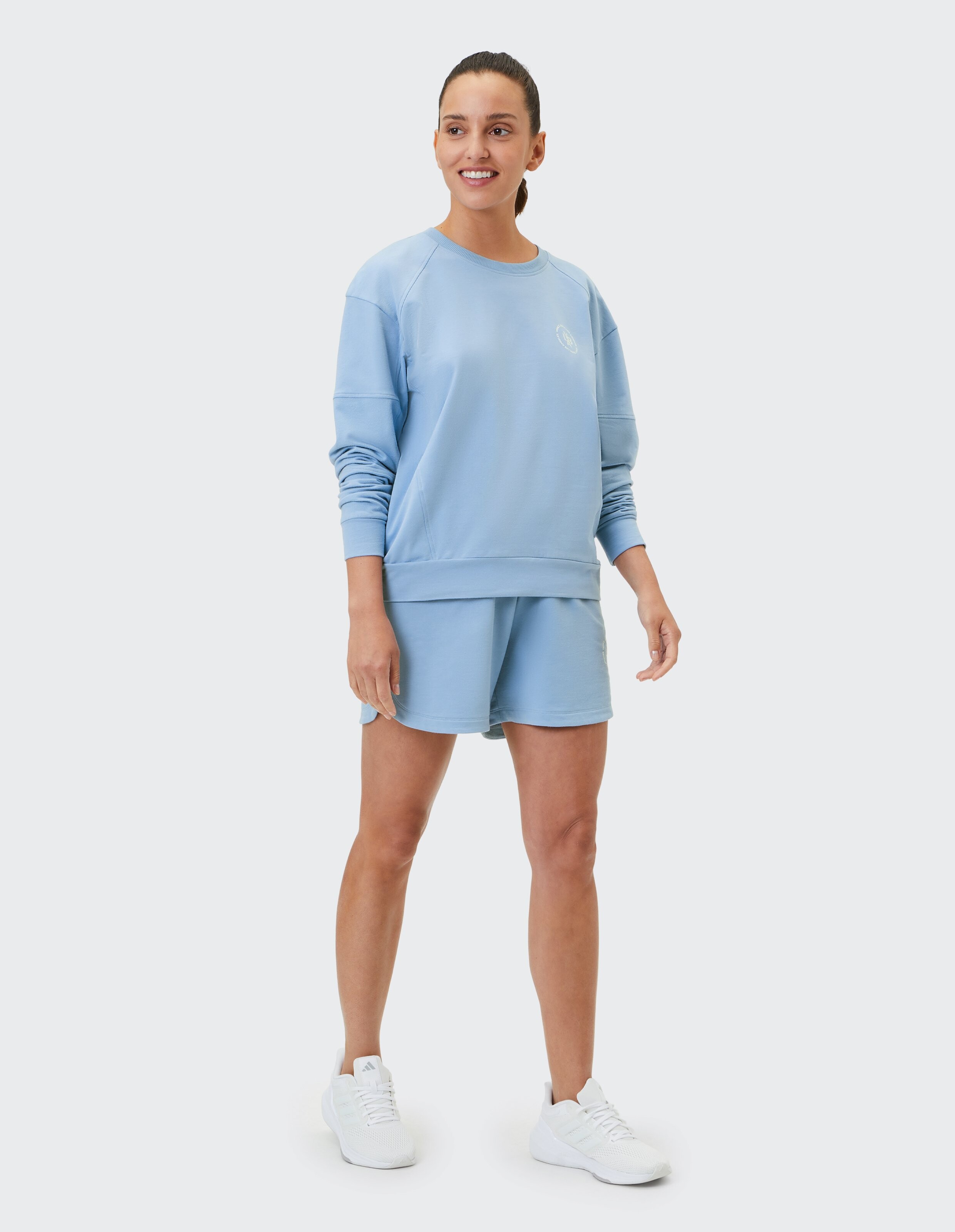 Frau in hellblauem, lässigem Sweatshirt und Shorts, perfekt zum Entspannen.