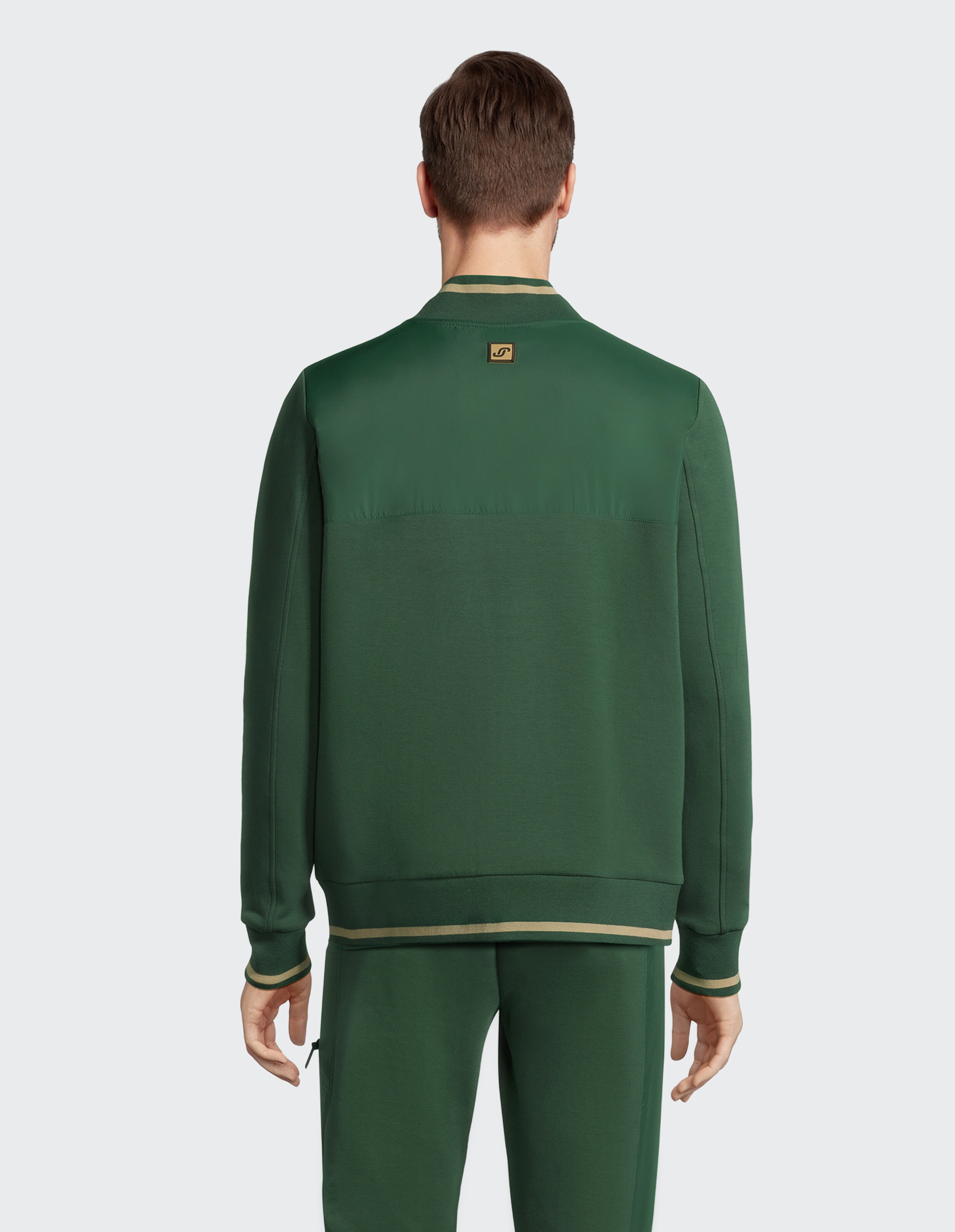 Mann trägt eine grüne ELBSAND-Freizeit-Bomberjacke mit gestreiftem Rippstrickbesatz.